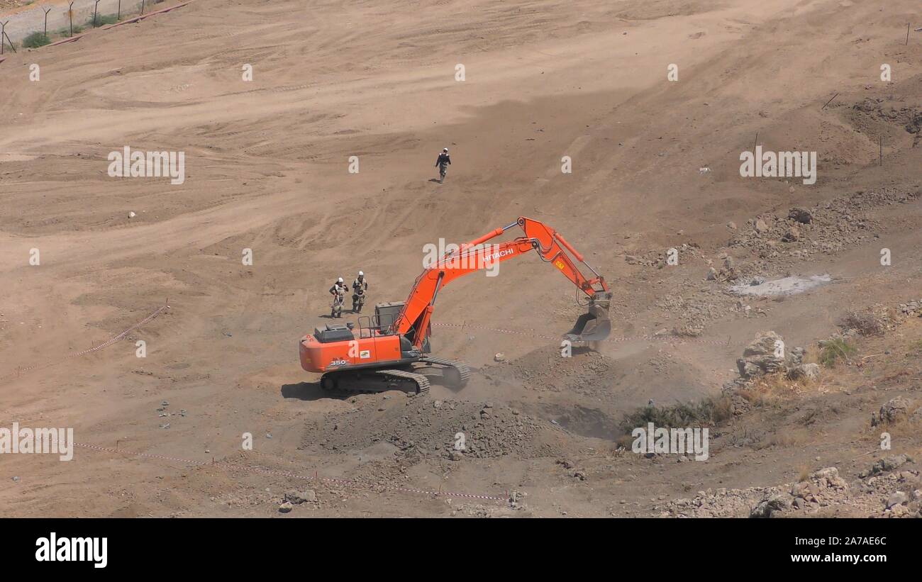 Enginers de 4M la défense nationale l'utilisation d'une excavatrice blindée avec talles et projection spéciale seaux pour enlever des mines de l'ancienne République de mines sur Gofra beach dans la mer de Galilée, Israël Banque D'Images