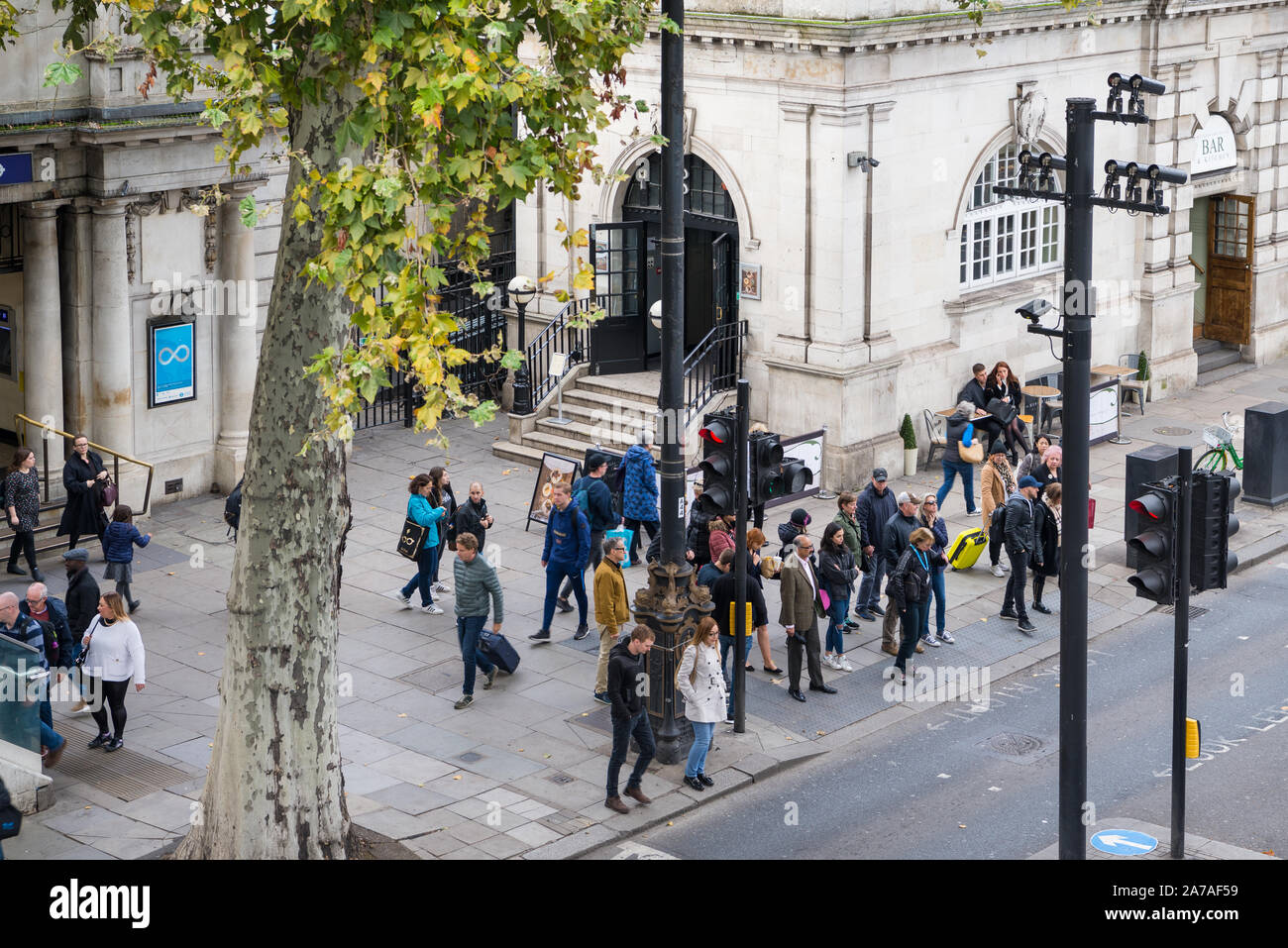 Les gens attendent à un passage pour piétons pour traverser la route sur Victoria Embankment en dehors de la station de métro Embankment, London, England, UK Banque D'Images