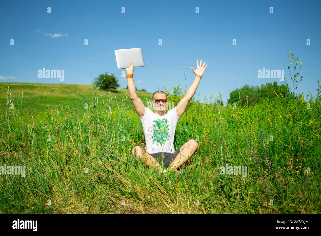 Man holding ordinateur portable à la main et mis sa main reste dans meadow Banque D'Images