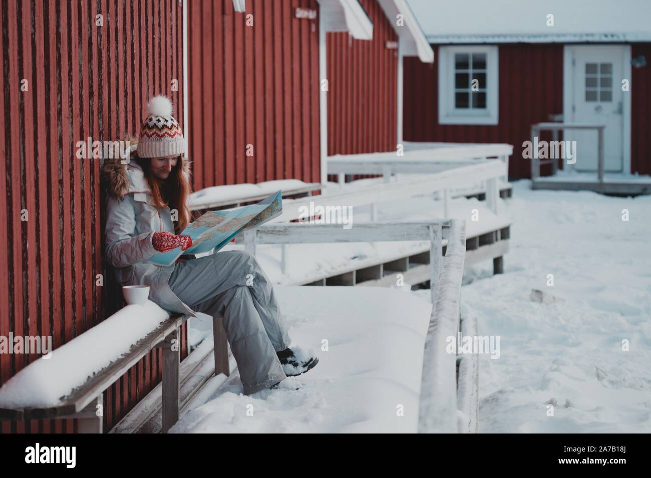 Fille de tourisme se trouve à proximité de rorbu avec une carte sur les îles Lofoten. La Norvège Banque D'Images