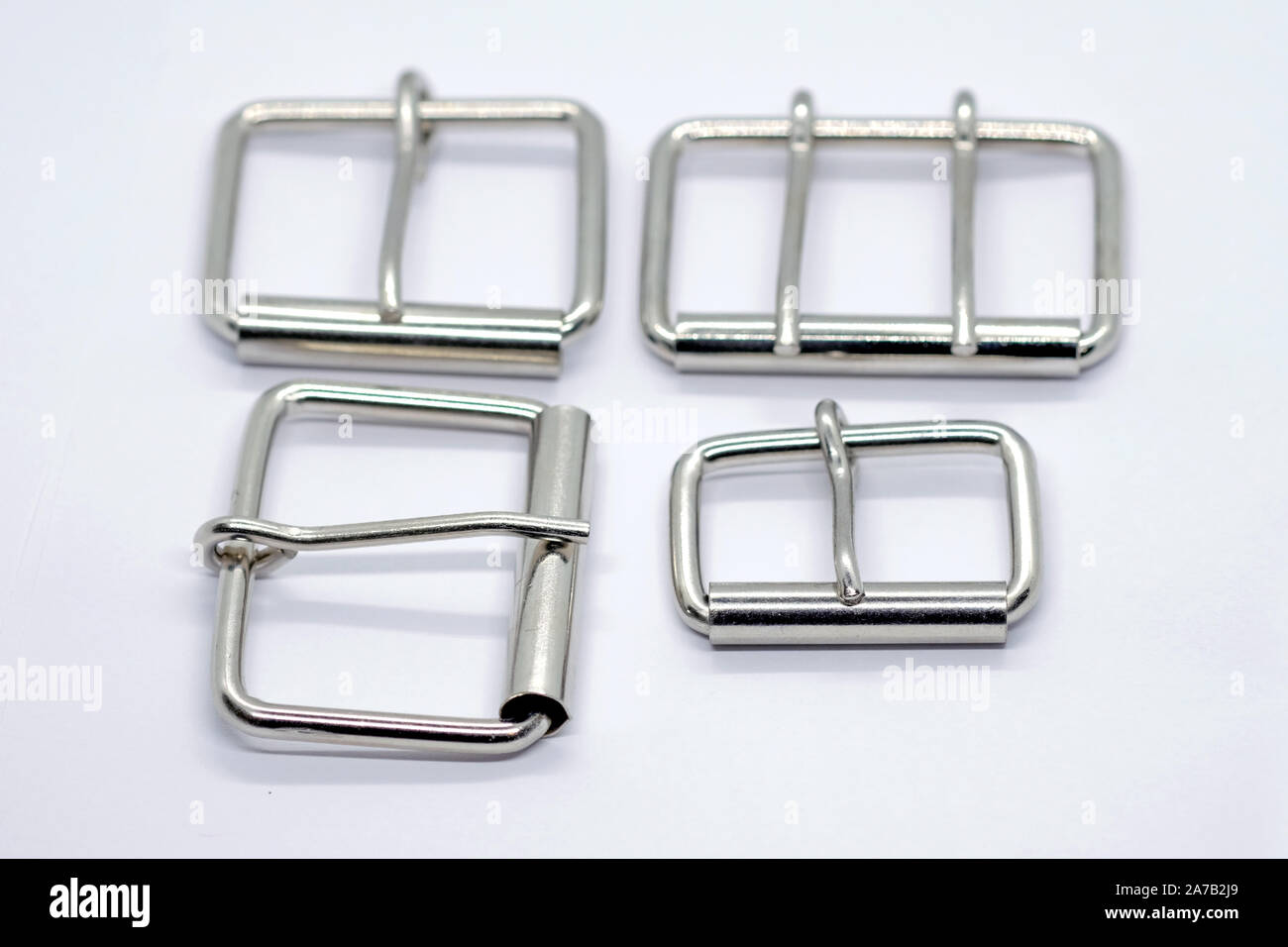 Boucles métalliques pour des colliers de chien avec la langue. Boucles d'argent de différentes tailles sur un fond blanc. Accessoires amovibles pour courroies. Banque D'Images