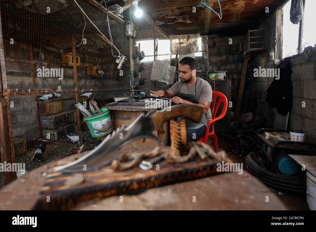 Gaza, la Palestine. 29 Oct, 2019. Saif Abu Azza, un Palestinien épée et poignard bouilloire, fer à repasser coupes-métaux pour faire des poignards dans son atelier de Khan Younis.L'épée et poignard est le plus vieux qu'un homme d'armes utilisées pour se défendre dans l'antiquité et ils sont considérés comme des outils de lutte contre l'ancienne. Ils sont utilisés comme des artefacts et certaines tribus dans différentes religions utilisent comme une arme symbolique. Credit : Yousef Masoud SOPA/Images/ZUMA/Alamy Fil Live News Banque D'Images