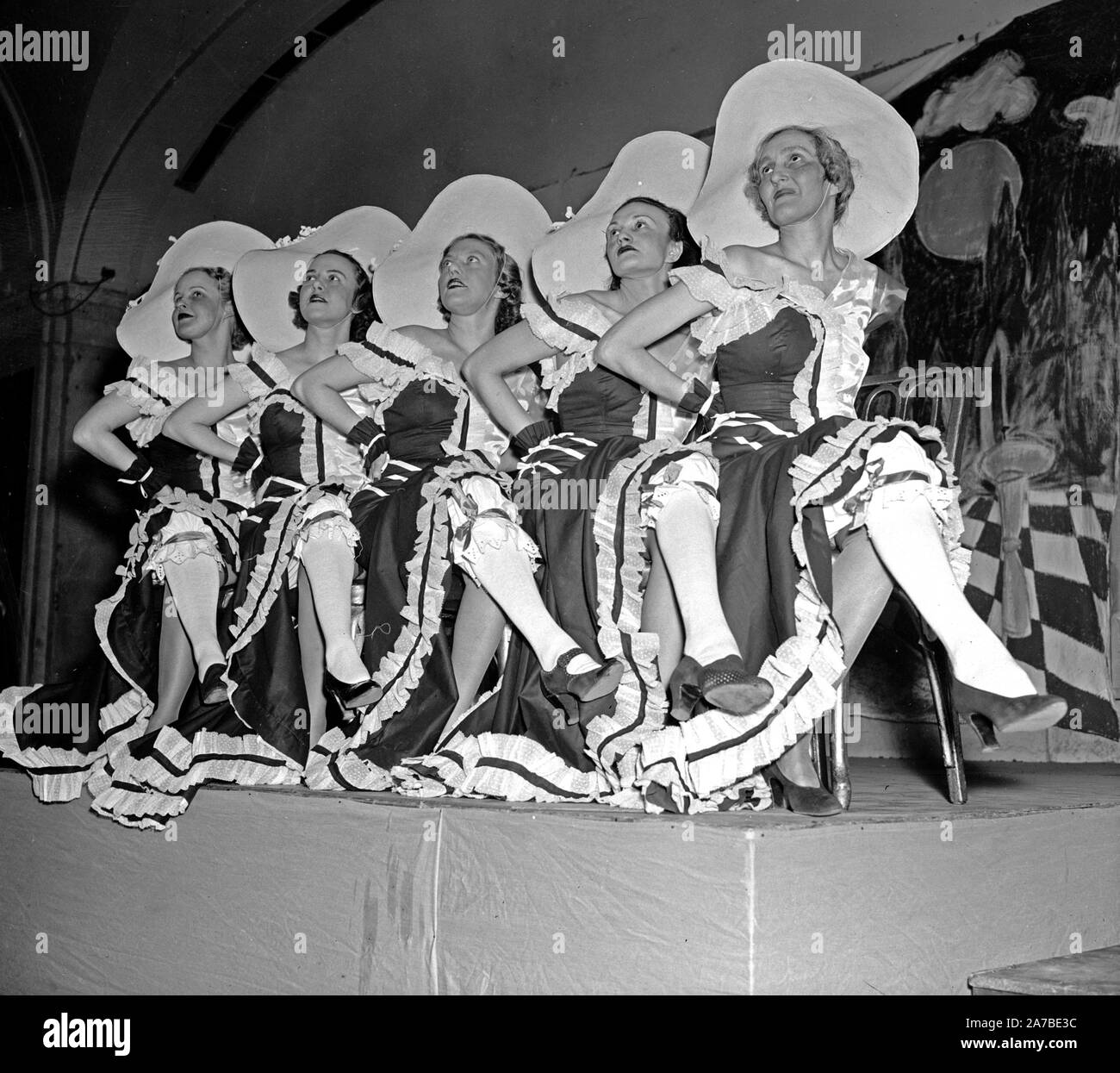 En 1938, cinq femmes habillés en vêtements fille montrer assis sur une scène Banque D'Images