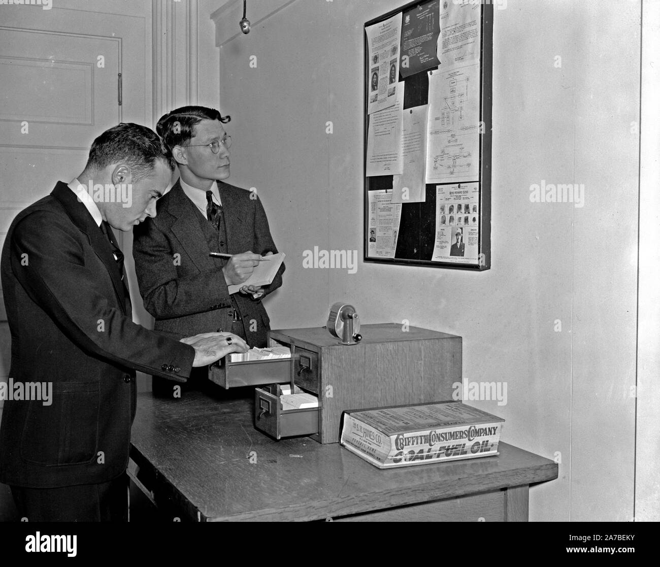 Les employés du Secret Service contrôle plus de tableau d'obtenir les dernières nouvelles de criminel ca. 1938 Banque D'Images