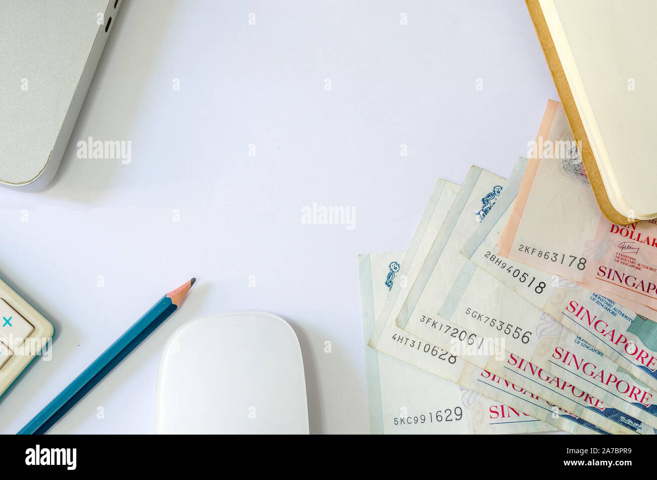 Cinquante dollars et dix dollars Singapour et de passeports et des calculatrices avec ordinateur portable sur un fond blanc Banque D'Images