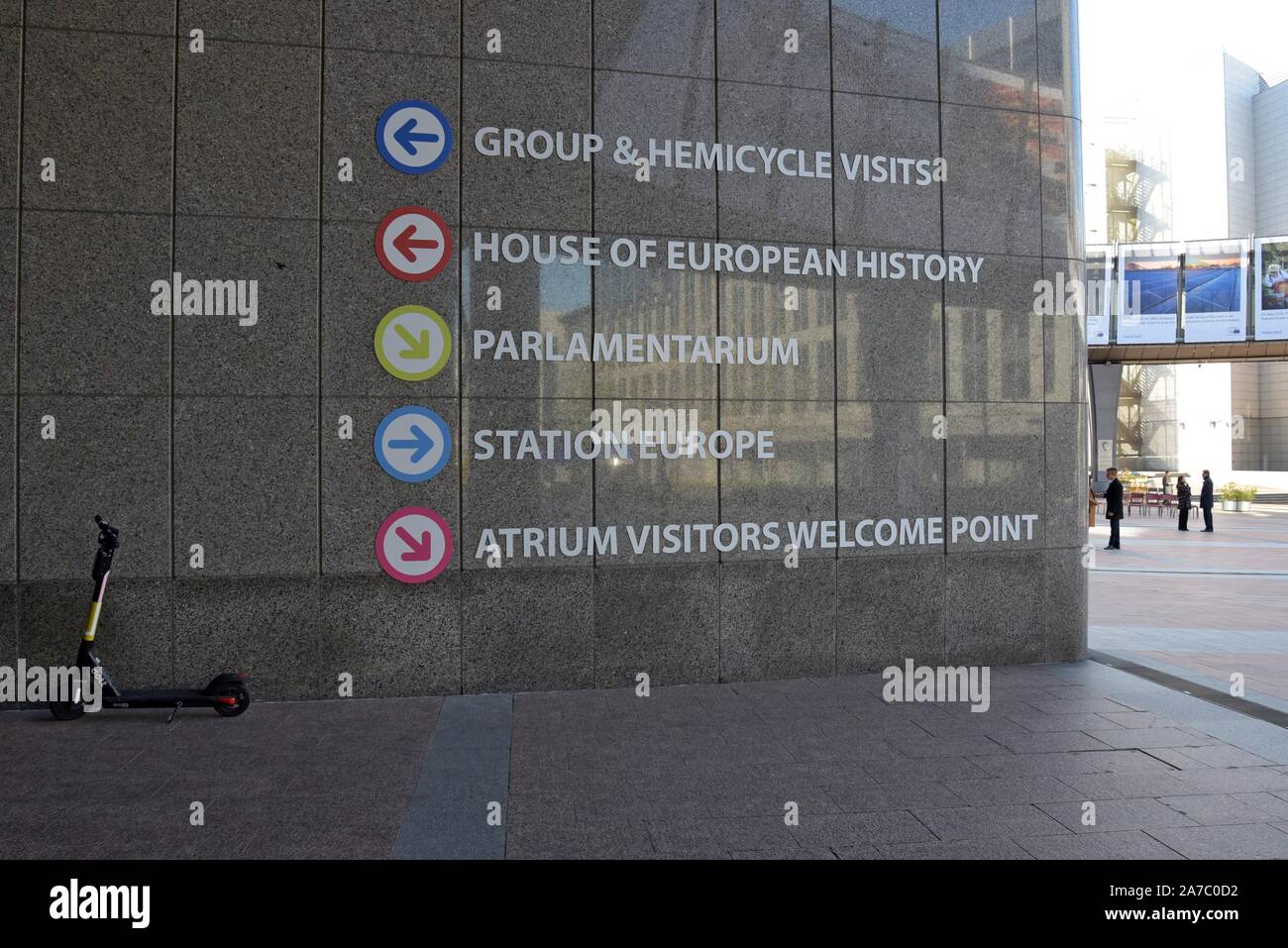 Dockless louer des scooters électriques stationné à côté de la direction de panneaux aux bâtiments du Parlement européen, Bruxelles, Belgique Banque D'Images