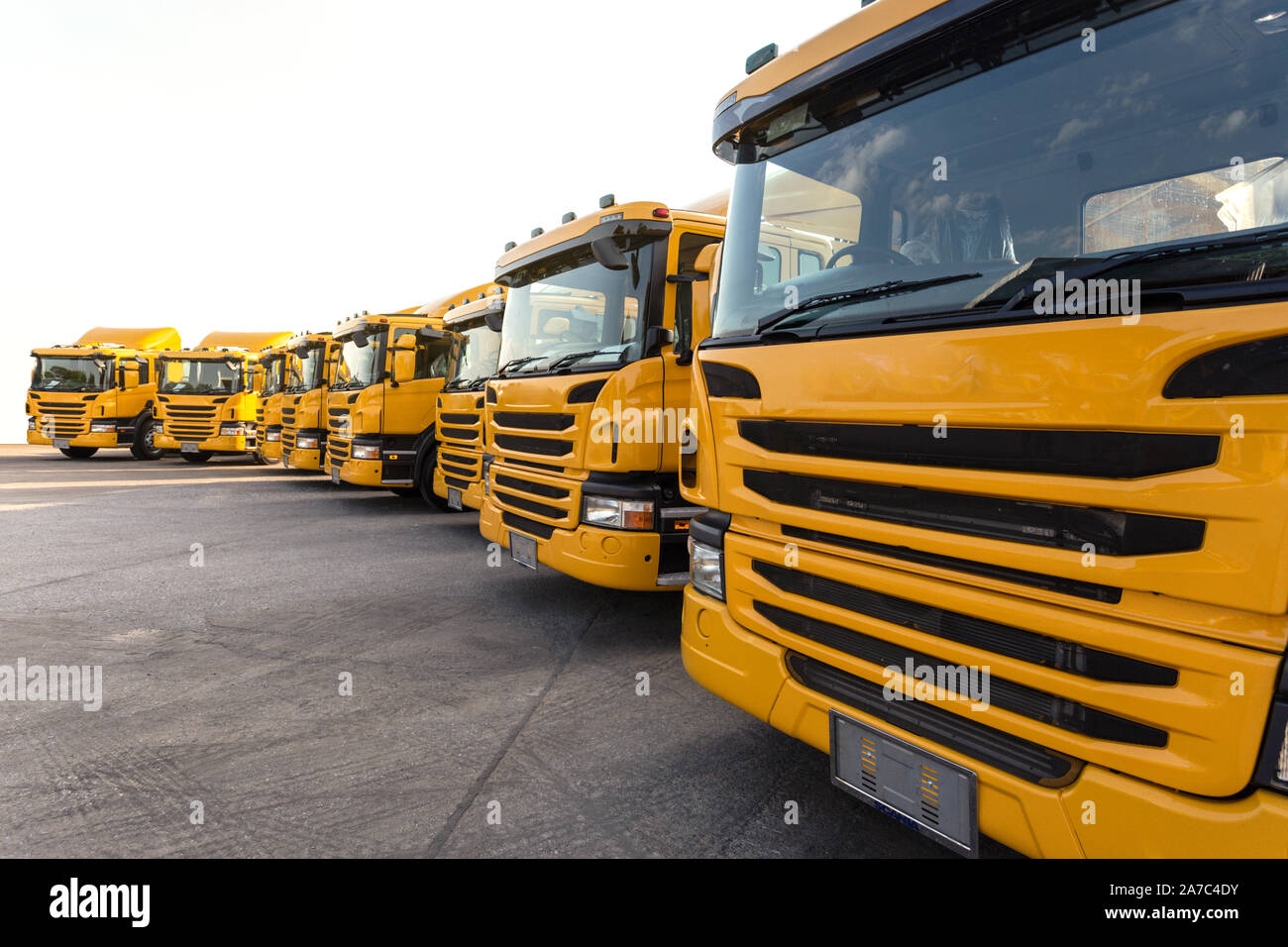 Nouvelle voiture camion remorque jaune flotte avec dépôt de conteneurs sur le parking de l'usine de fabrication de camions pour livrer aux affaires voyage et une compagnie logistique cl Banque D'Images