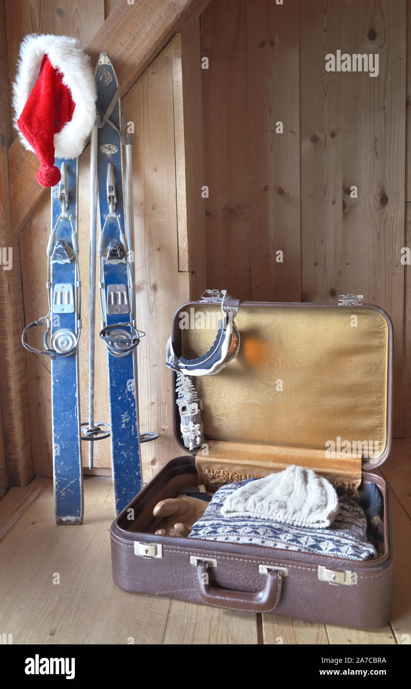 Des vêtements chauds dans une valise sur le sol et le père Noël la pendaison d'un vieux chalet de ski à l'intérieur d'un Banque D'Images