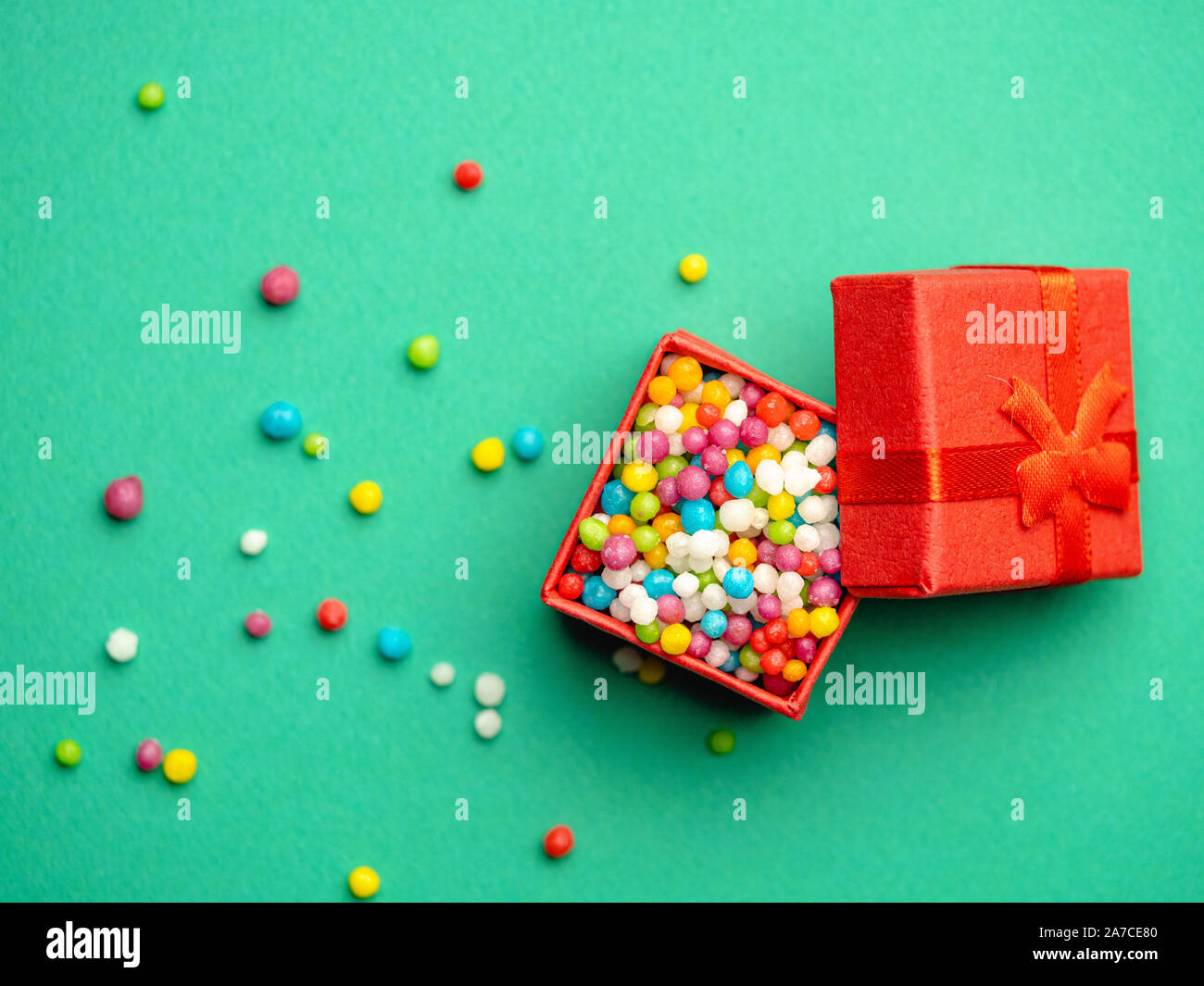 Mise en page créative de boîte-cadeau rempli de bonbons colorés sur fond vert. Banque D'Images