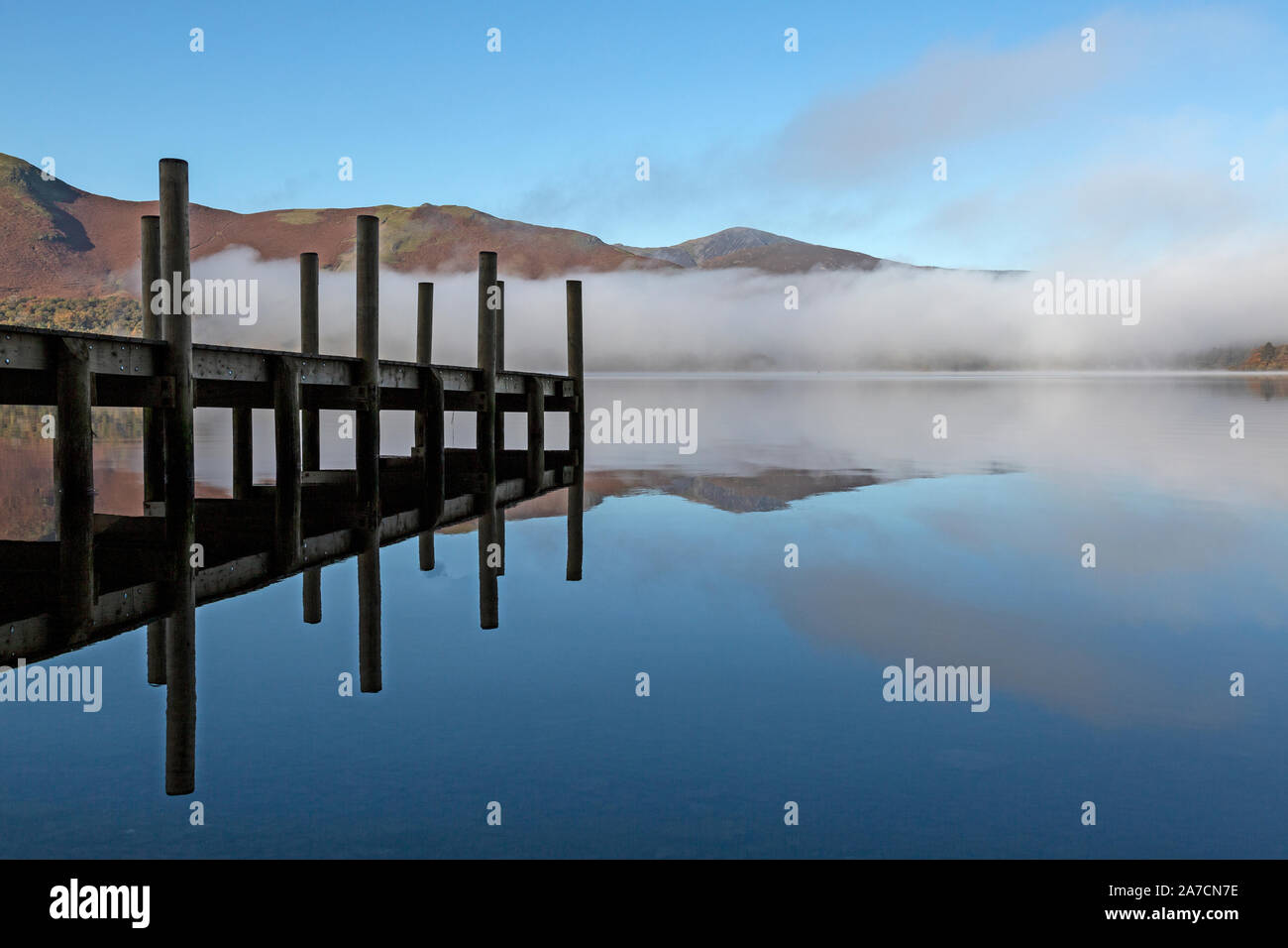 Tôt le matin dans la région de Derwent Water Parc national de Lake District en Angleterre. Brume sur le lac. Embarcadère pour petits bateaux sur la gauche. Banque D'Images