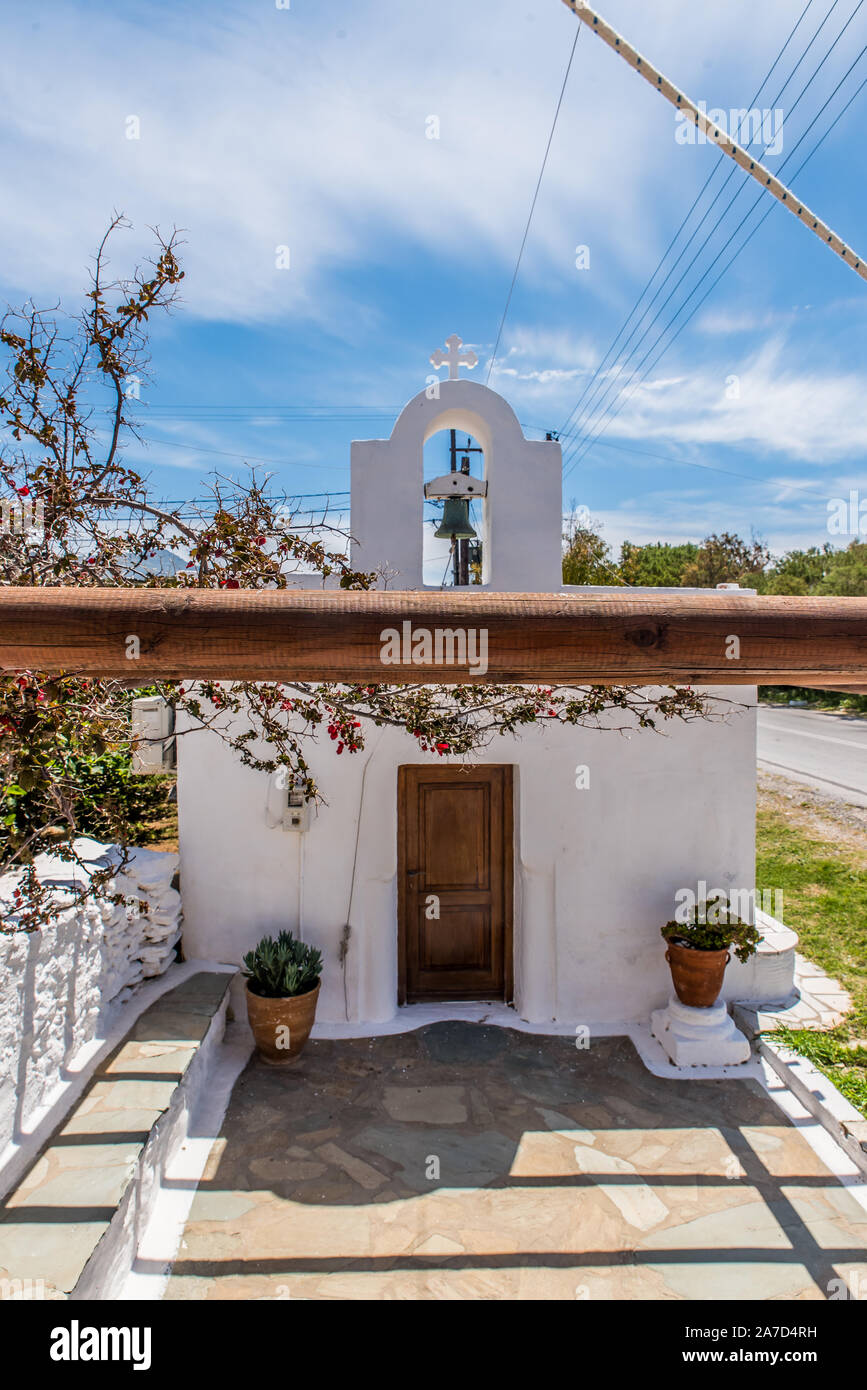 Une église traditionnelle à Andros avec un beau bougainvilliers violets dans la cour Banque D'Images