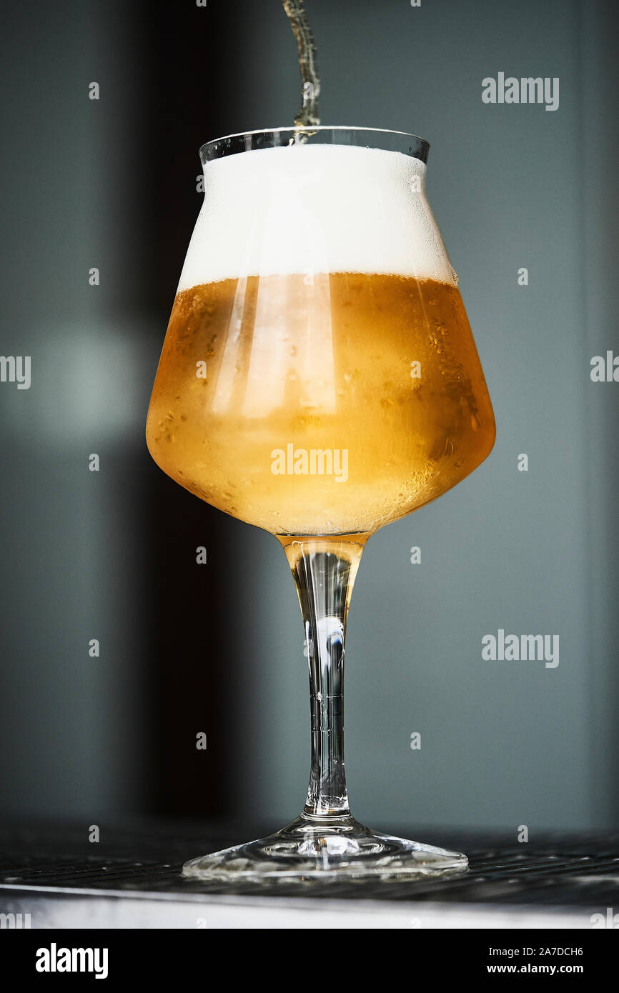 Verre de bière pendant qu'il est rempli Banque D'Images