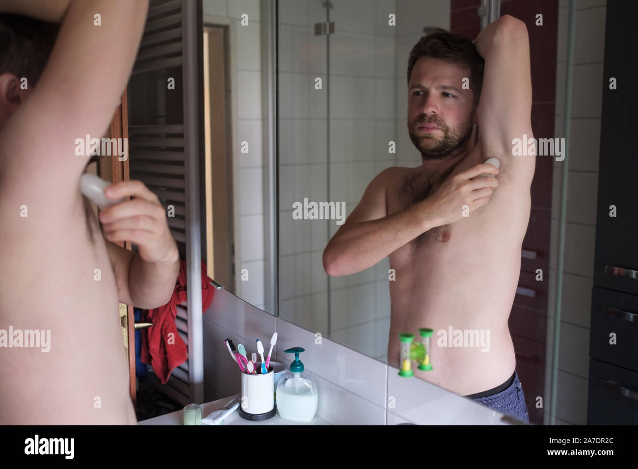 Nu Dans La Salle De Bain L'homme torse nu beau mettre du déodorant dans la salle de bain le matin Photo Stock - Alamy