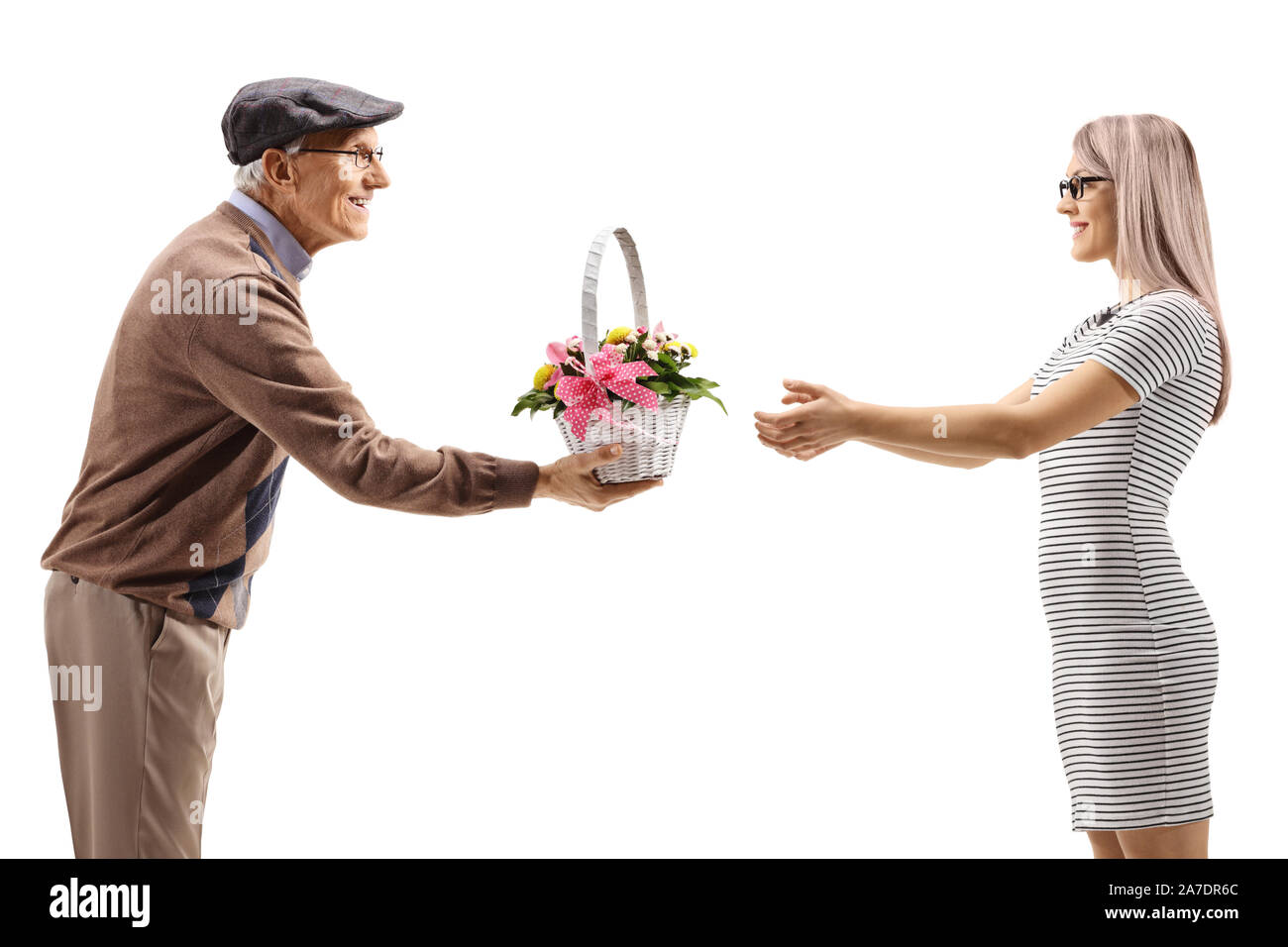 Homme âgé donnant un panier de fleurs à une jeune femme isolée sur fond blanc Banque D'Images