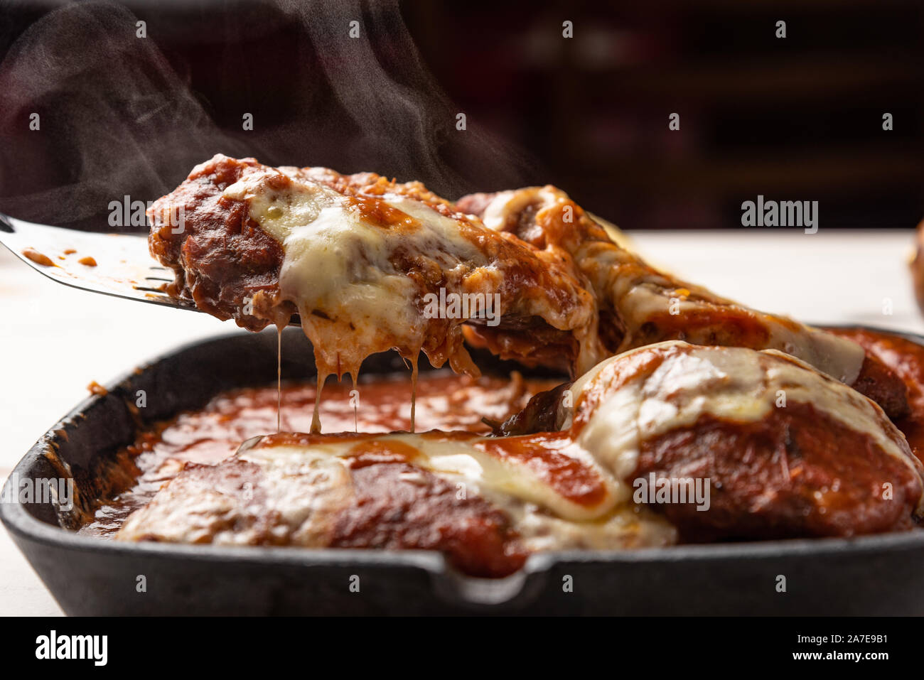 Parmegiana Steak aussi connu que Filet Parmegiana dans une poêle de fer  noir sur un fond blanc en bois, fromage et sauce tomate. Lumière douce,  angle view Photo Stock - Alamy