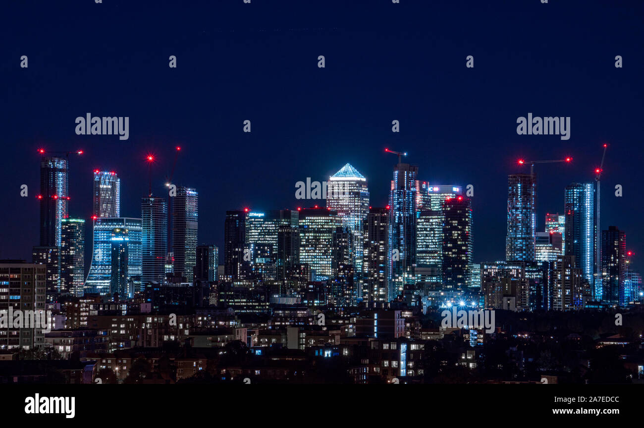 London / United Kingdom - 4 octobre 2019 : Nuit panorama du quartier financier de Canary Wharf pris de Blackheath Banque D'Images