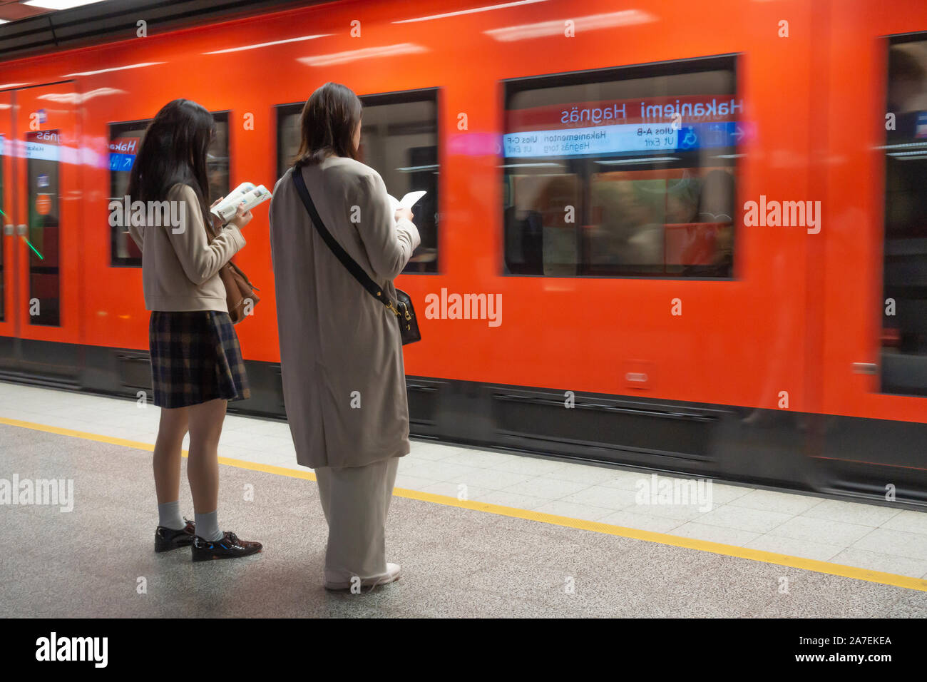Deux femmes asiatiques attendent un métro pour la station de métro arriveat Hakaniemi à Helsinki, en Finlande Banque D'Images Deux femmes asiatiques attendent un métro pour la station de métro arriveat Hakaniemi à Helsinki, en Finlande Banque D'Images