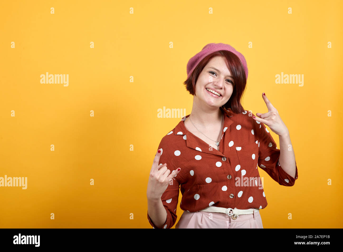 Belle jeune femme brune fait sourire et rire symbole rock Banque D'Images