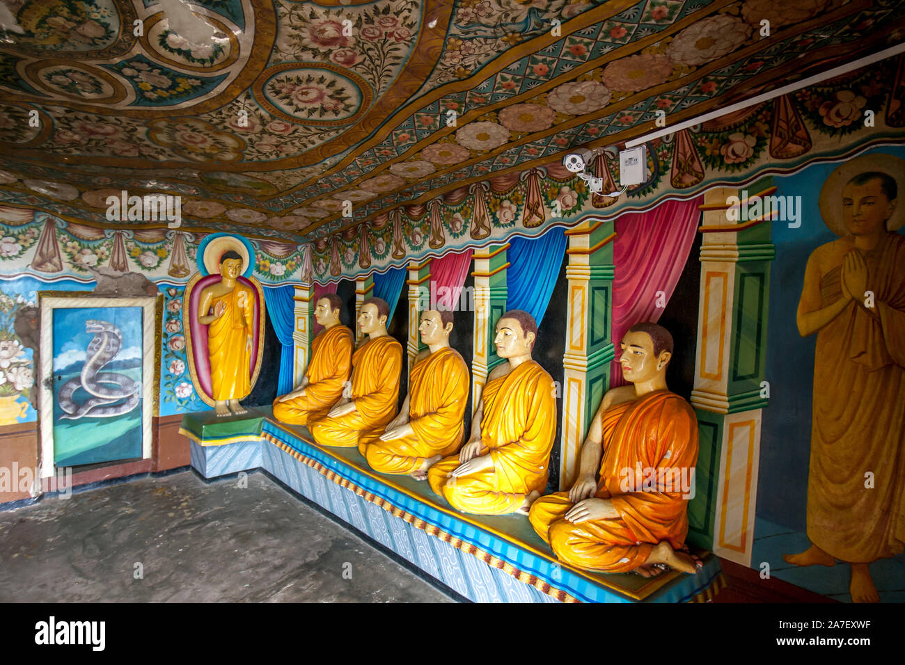 Moine agenouillé dans le Naga Vihara statues (sixième culte) à l'ancien temple de Mulkirigala rock au Sri Lanka. Banque D'Images