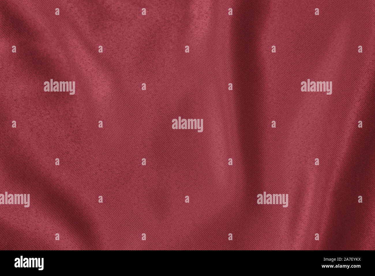 Arrière-plan de couleur rouge foncé de tissu drapé doux. Belle Soie satin tissu texturé pour la confection des vêtements et des rideaux. Texture textile élégant. Banque D'Images