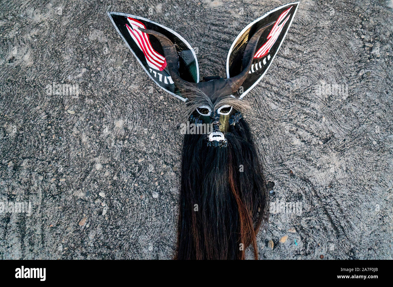 Cuajinicuilapa, au Mexique. 06Th Nov, 2019. Un masque du diable se trouve sur le trottoir pendant la traditionnelle 'Devil's Dance' dans le cadre de la 'Day of the Dead'. Comme chaque année, les villes de la Costa Chica de Guerrero, dans le sud du Mexique, célébrer les morts avec la danse héritée de leurs ancêtres d'origine africaine. La danse des Diables, chorégraphie avec laquelle ils sautent et stomp à travers les rues de Cuajinicuilapa et amener les âmes des morts dans les maisons de leurs proches. Credit : Jair Cabrera/dpa/Alamy Live News Banque D'Images