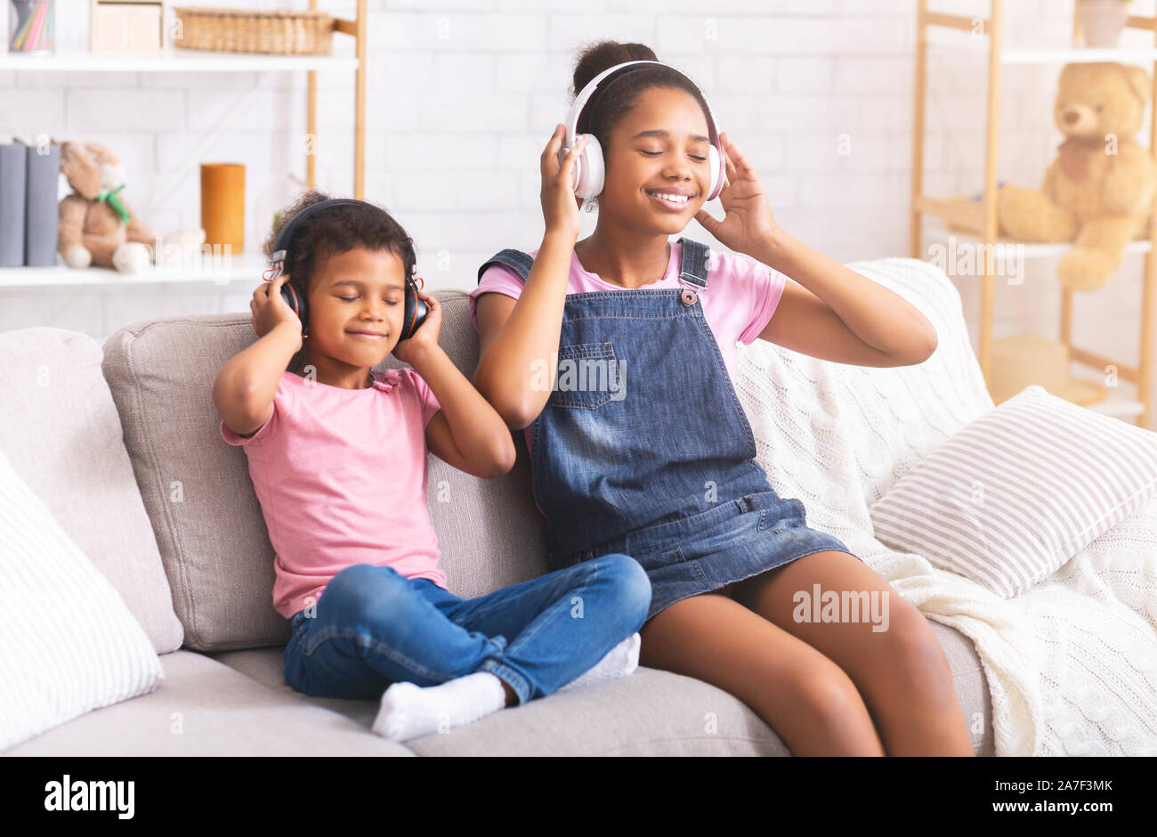 Deux sœurs africaines dans des écouteurs sans fil moderne Banque D'Images