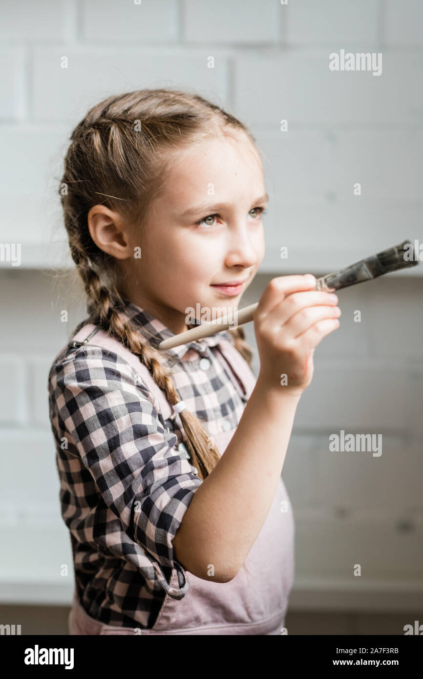 Creative et adorable lycéenne holding paintbrush en allant peindre photo Banque D'Images