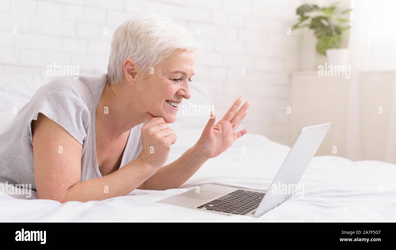Grand-mère joyeuse de parler avec des parents via digital tablet online Banque D'Images