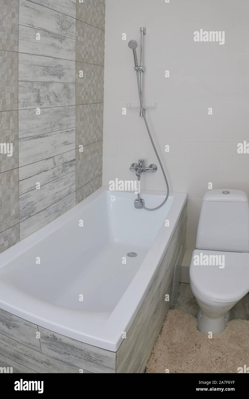 Petite salle de bains moderne avec baignoire, robinet et toilettes Banque D'Images