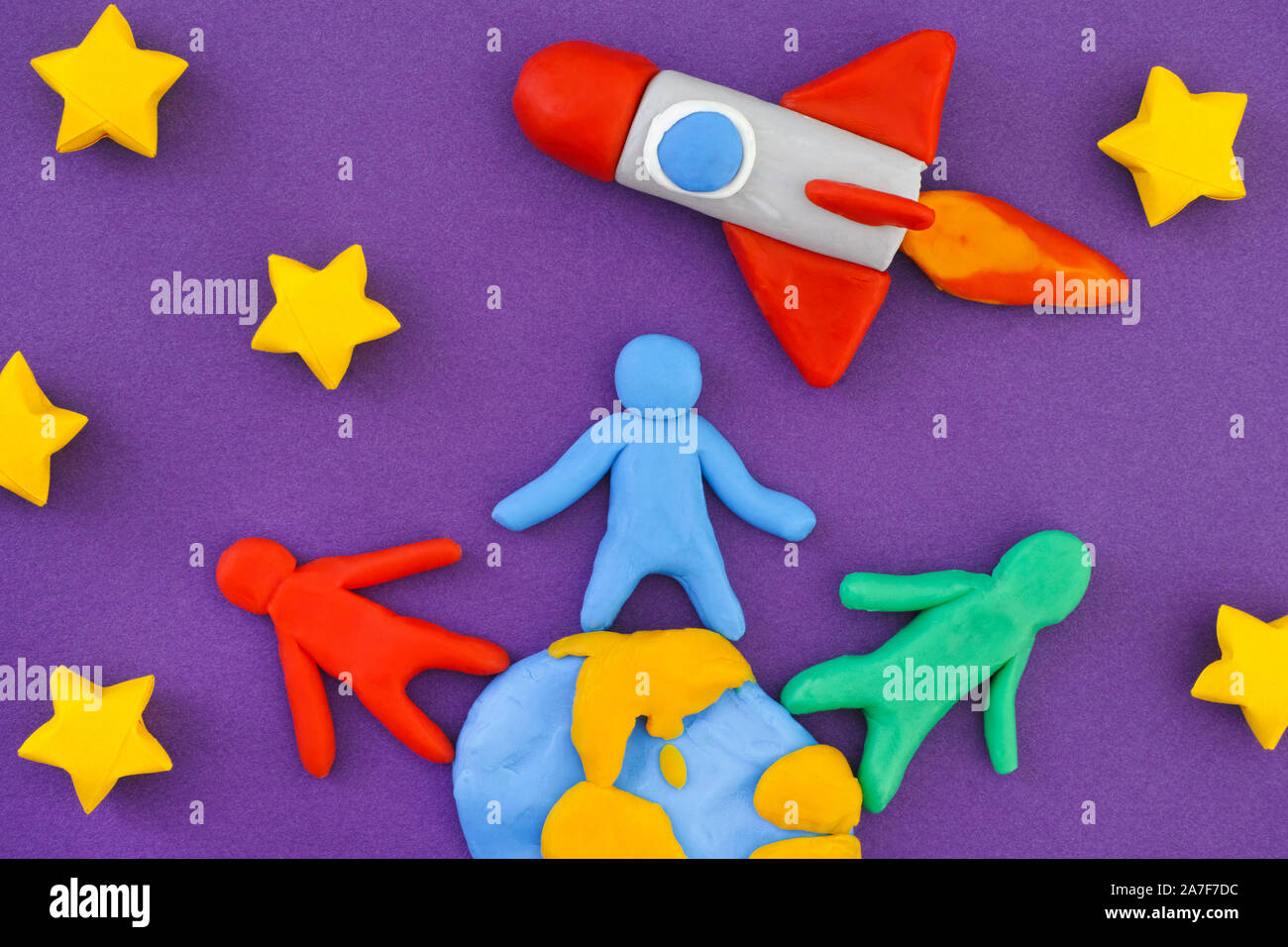 Personnes debout sur la terre et le lancement de fusée spatiale dans l'espace. People, Planet Earth and Space Rocket sont faits de pâte à modeler l'argile (jouer). Banque D'Images