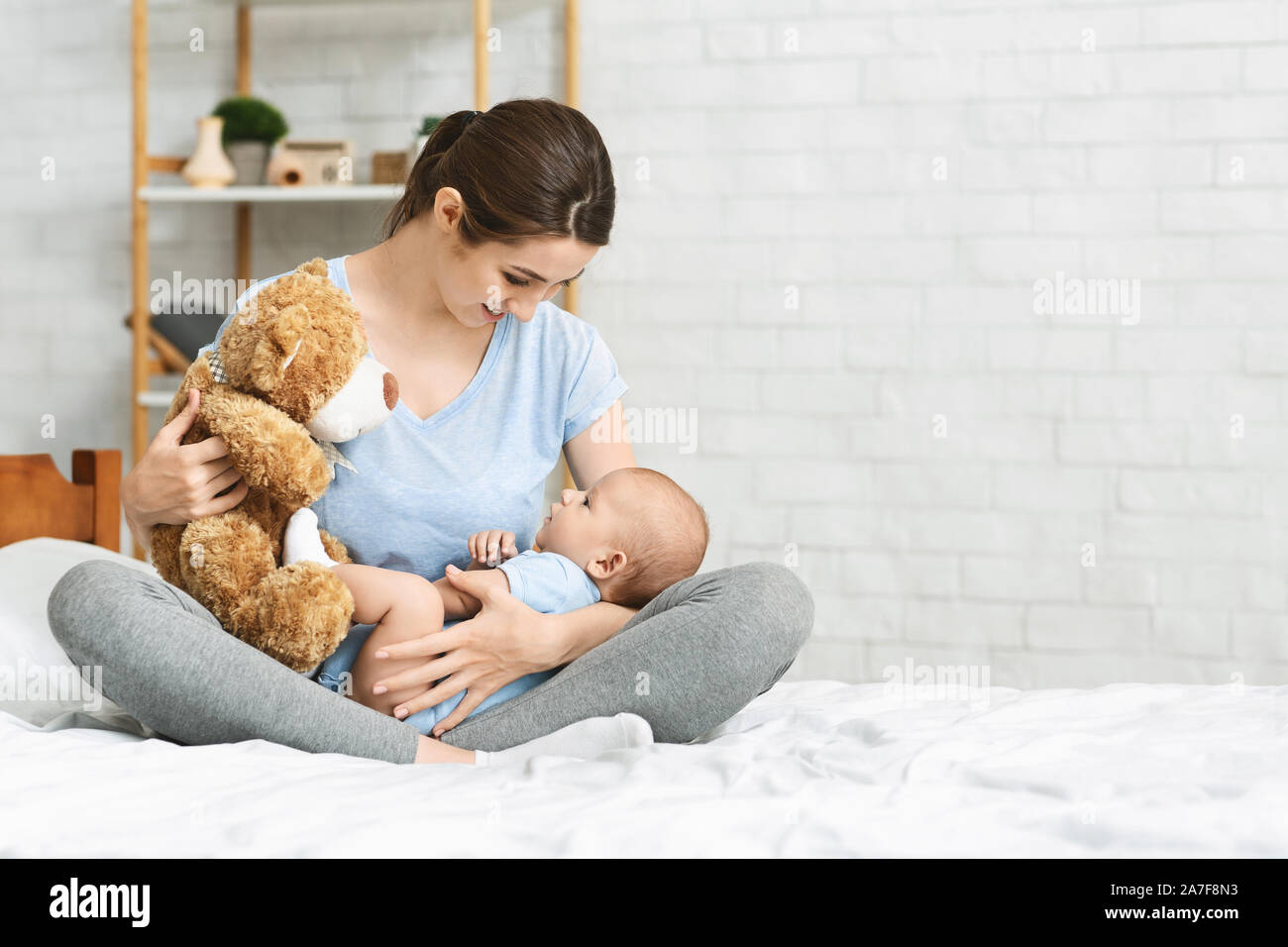 Jeune mère de teddy bear, jouant avec son nouveau-né Banque D'Images