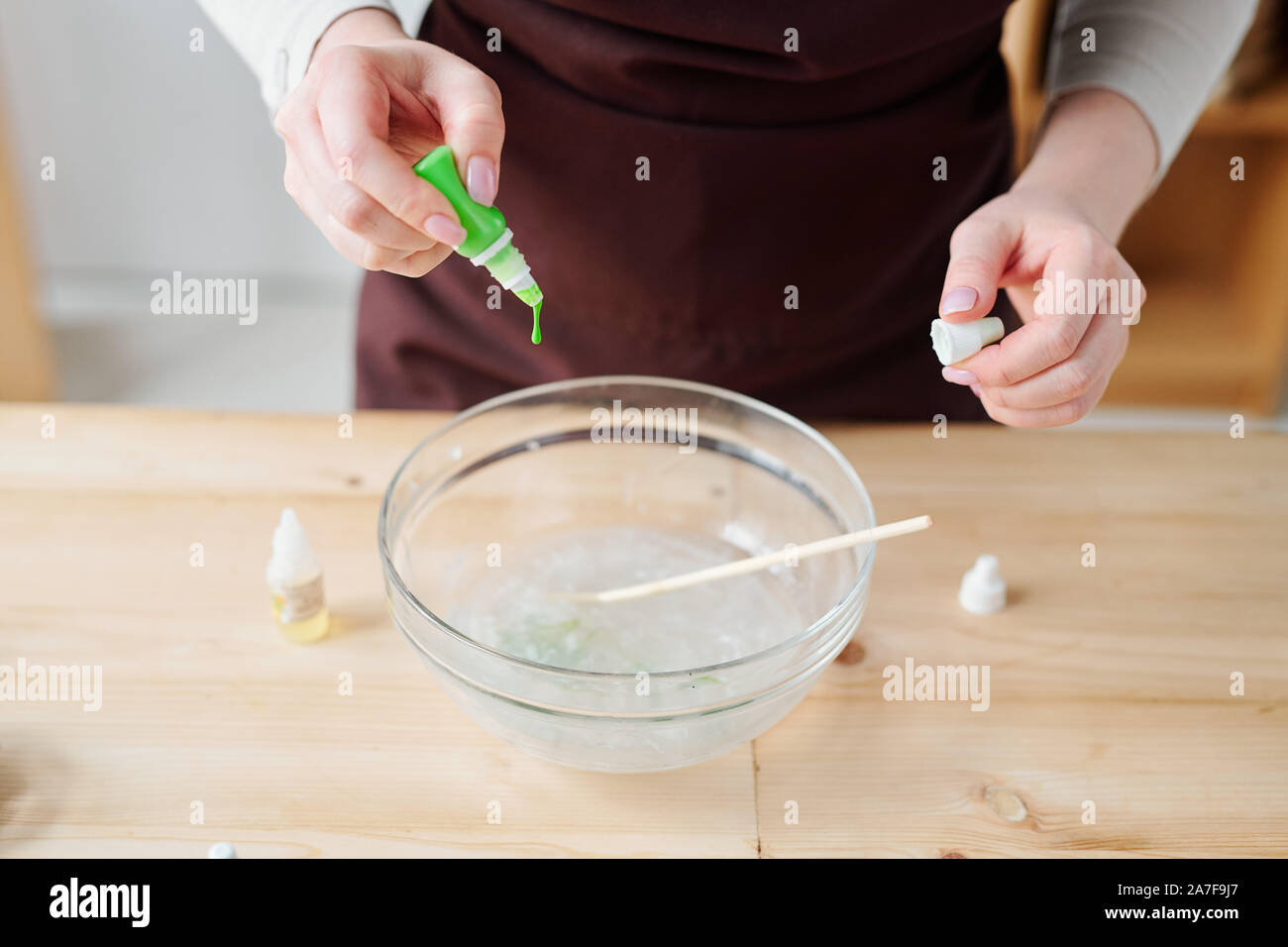 Mains de femme créative de couleur vert bouteille dans la masse de savon liquide Banque D'Images