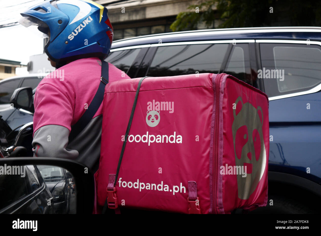ANTIPOLO CITY, PHILIPPINES - le 29 octobre 2019 : moto populaire pilote livraison alimentaire attend une congestion du trafic route de débit. Banque D'Images