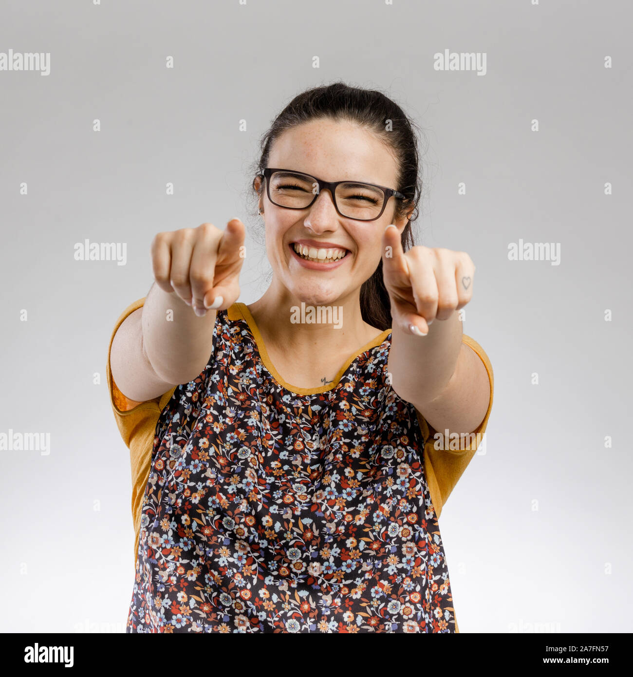 Happy woman smiling et pointant vers l'appareil photo Banque D'Images