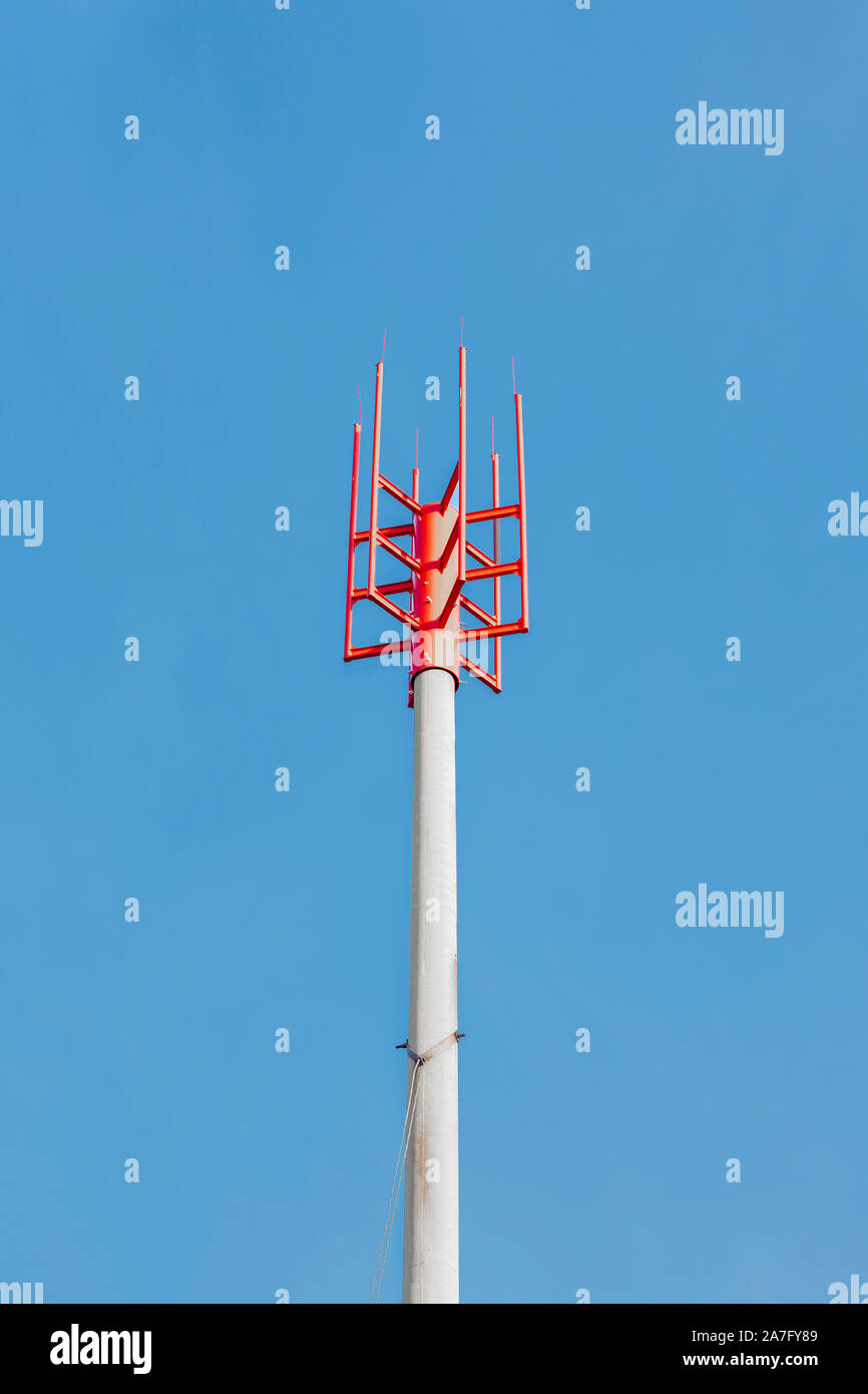 Un poteau avec une pointe en métal rouge de plusieurs dessins ou modèles contre un ciel bleu - un paratonnerre un paratonnerre sur le site de construction d'une maison en vertu de constru Banque D'Images