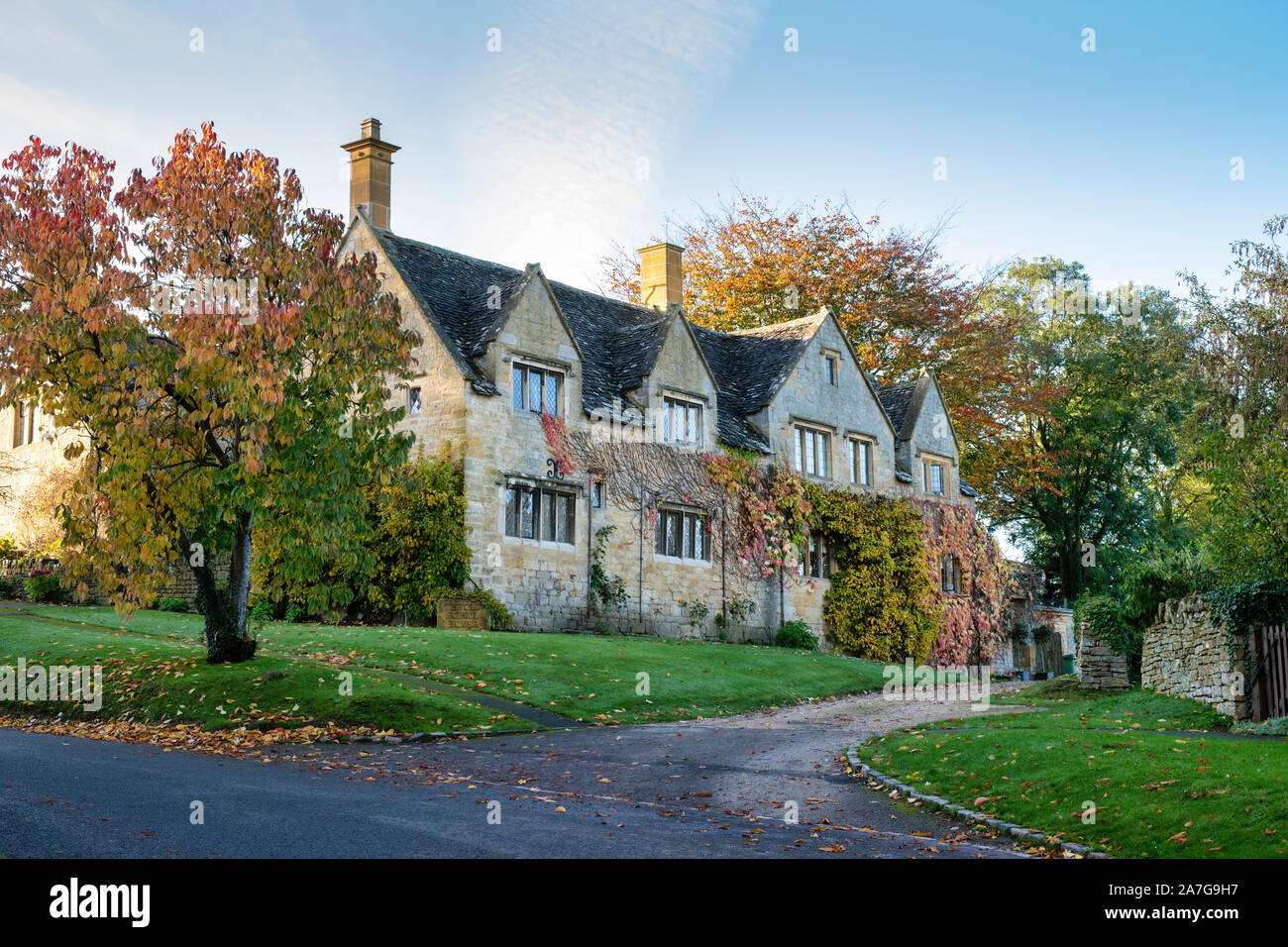 Maison en pierre de Cotswold et un cheval châtaignier en automne. Saintbury, Cotswolds, Gloucestershire, Angleterre Banque D'Images