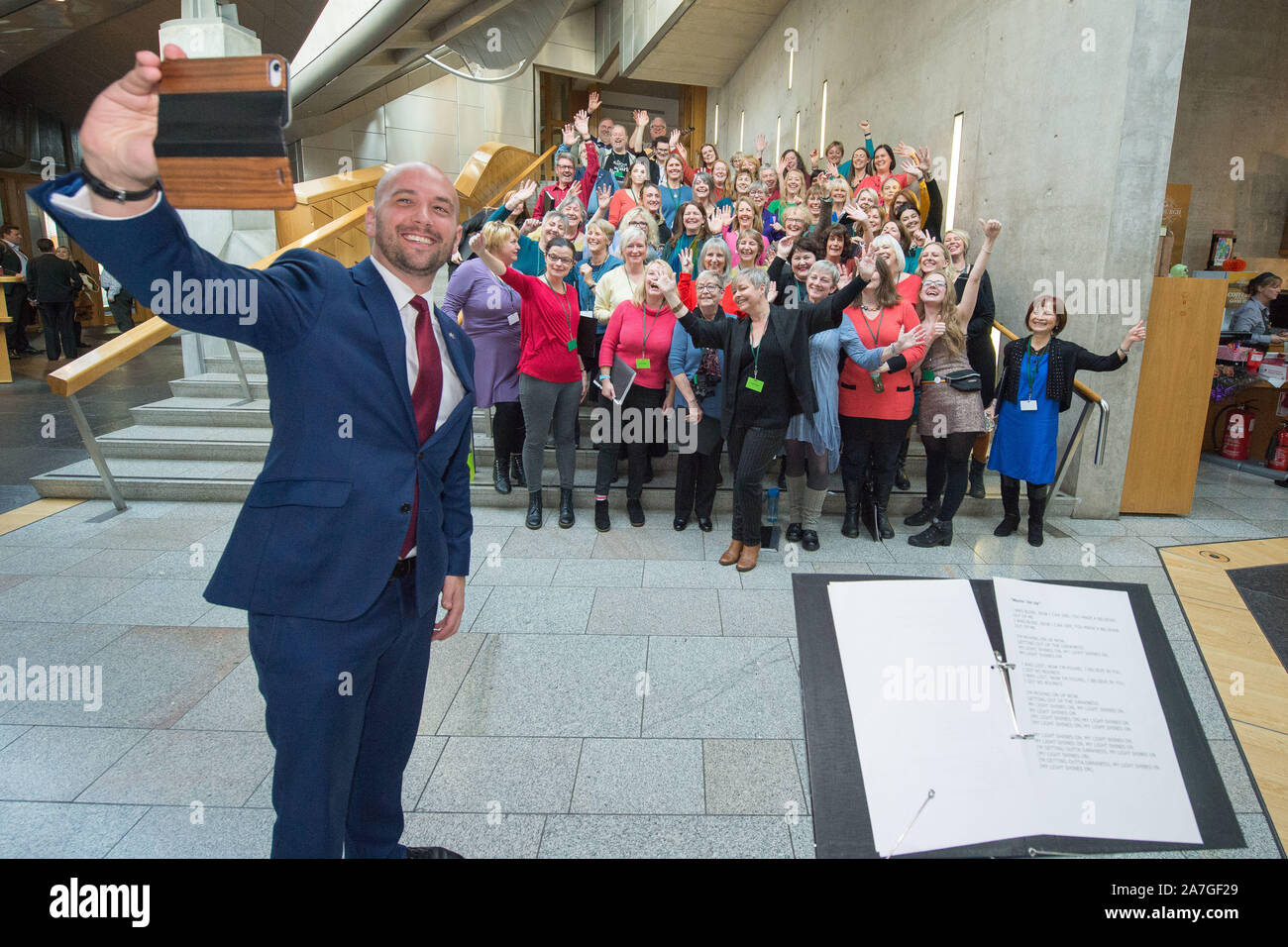 Edinburgh, Royaume-Uni. 31 octobre 2019. Photo : Ben Macpherson prend une MSP avec la Chorale selfies Soundhouse après avoir effectué sur les marches de l'entrée au jardin du Parlement écossais. Soundhouse Choir est une chorale communautaire bienvenue, pas d'expérience ou les compétences en lecture sont nécessaires. Formé en 2016 par le Directeur Musical Heather Macleod, il attire désormais plus de 100 membres et a joué dans certains des plus prestigieux d'Édimbourg Greyfriars Kirk y compris les salles, Usher Hall et Queens Hall (qui cautionnent le chœur) et le Parlement écossais ! Crédit : Colin Fisher/CDFIMAGES.COM Banque D'Images