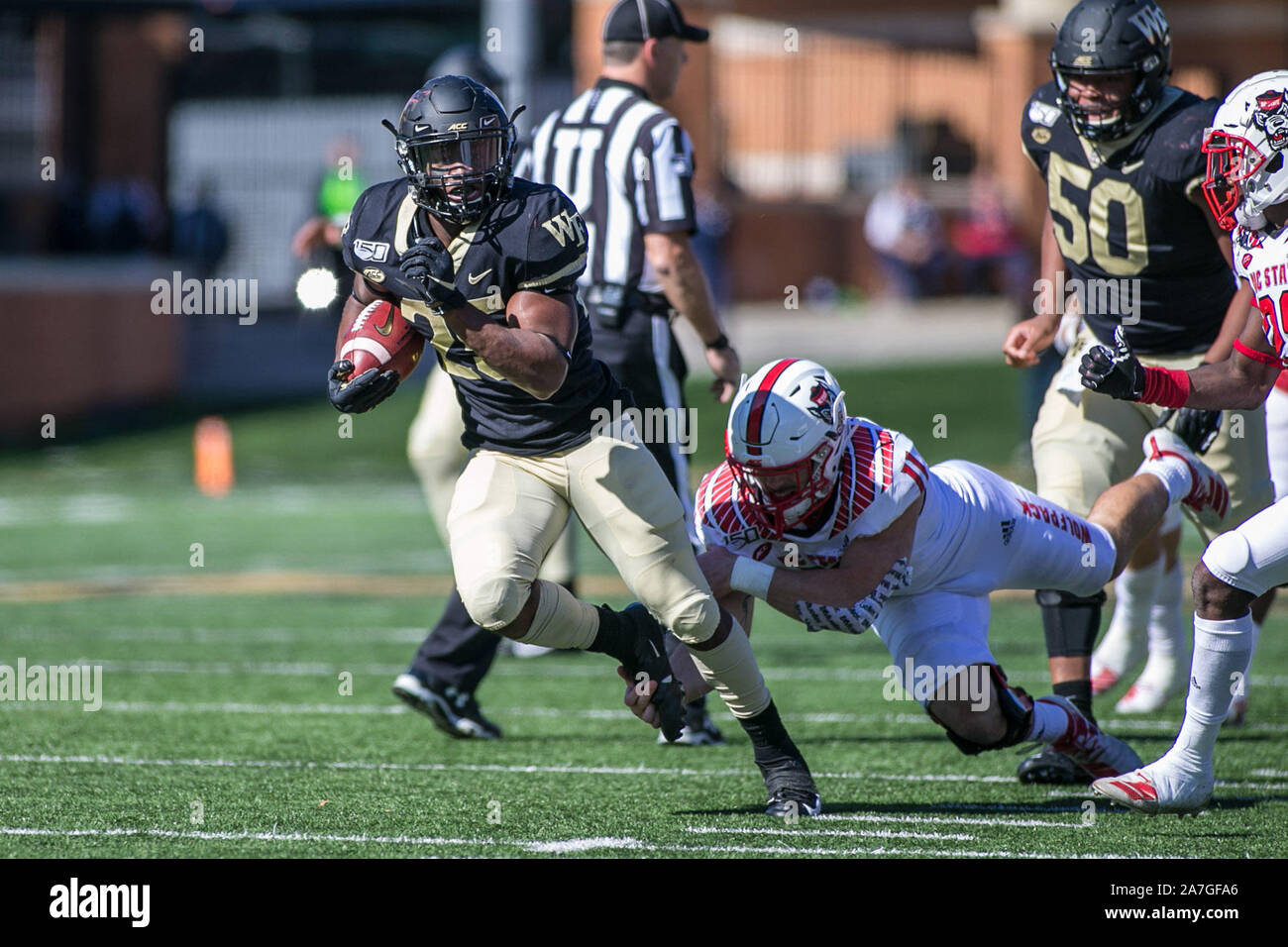 Winston-Salem, NC, USA. 2e Nov, 2019. Service Démon des forêts aux diacres d'utiliser de nouveau Kenneth Walker III (25) exécute pour une première en NCAA football action entre la NC State Wolfpack et Wake Forest Demon diacres à BB&T Field à Winston-Salem, NC. Jonathan Huff/CSM/Alamy Live News Banque D'Images