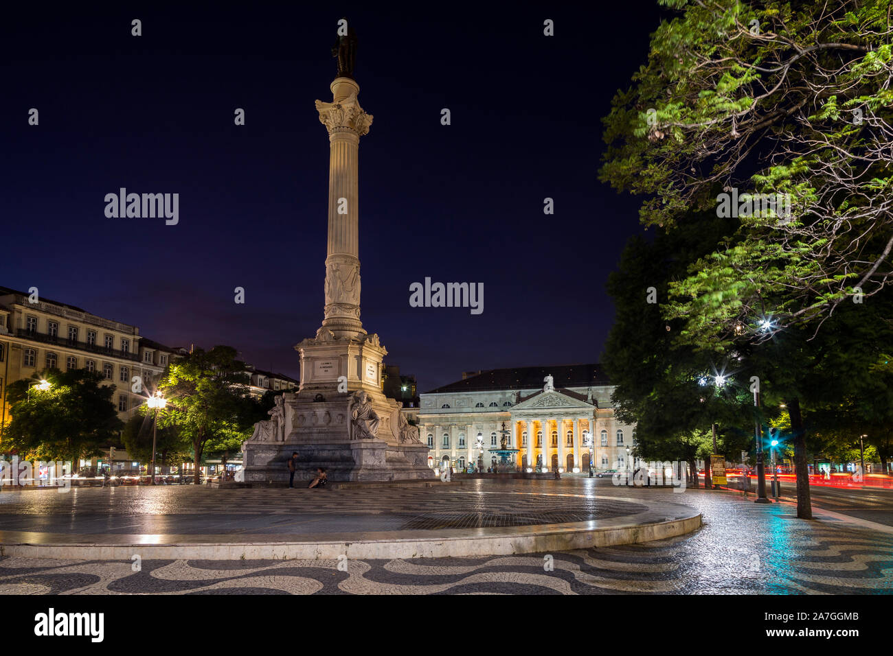 Les gens et la colonne et statue de Dom Pedro IV à la place Rossio (Praça do Rossio) dans le quartier de Baixa à Lisbonne, au Portugal, au crépuscule. Banque D'Images