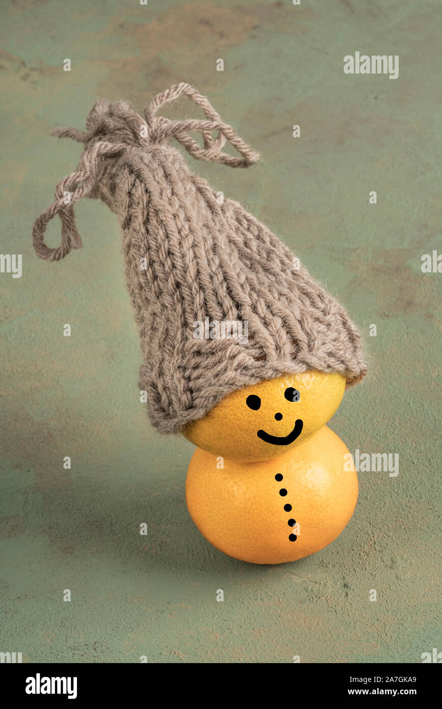 La mandarine fruits ont smiley face, wearing hat on green with copy space Banque D'Images