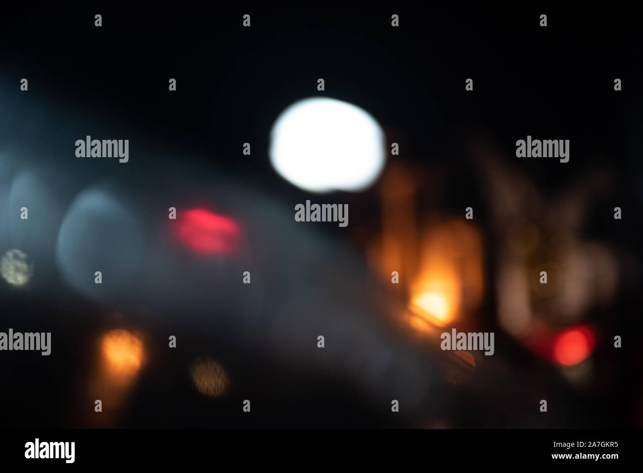Hors focus abstract les phares de voitures sous la pluie avec l'espace pour le texte sur un fond sombre Banque D'Images