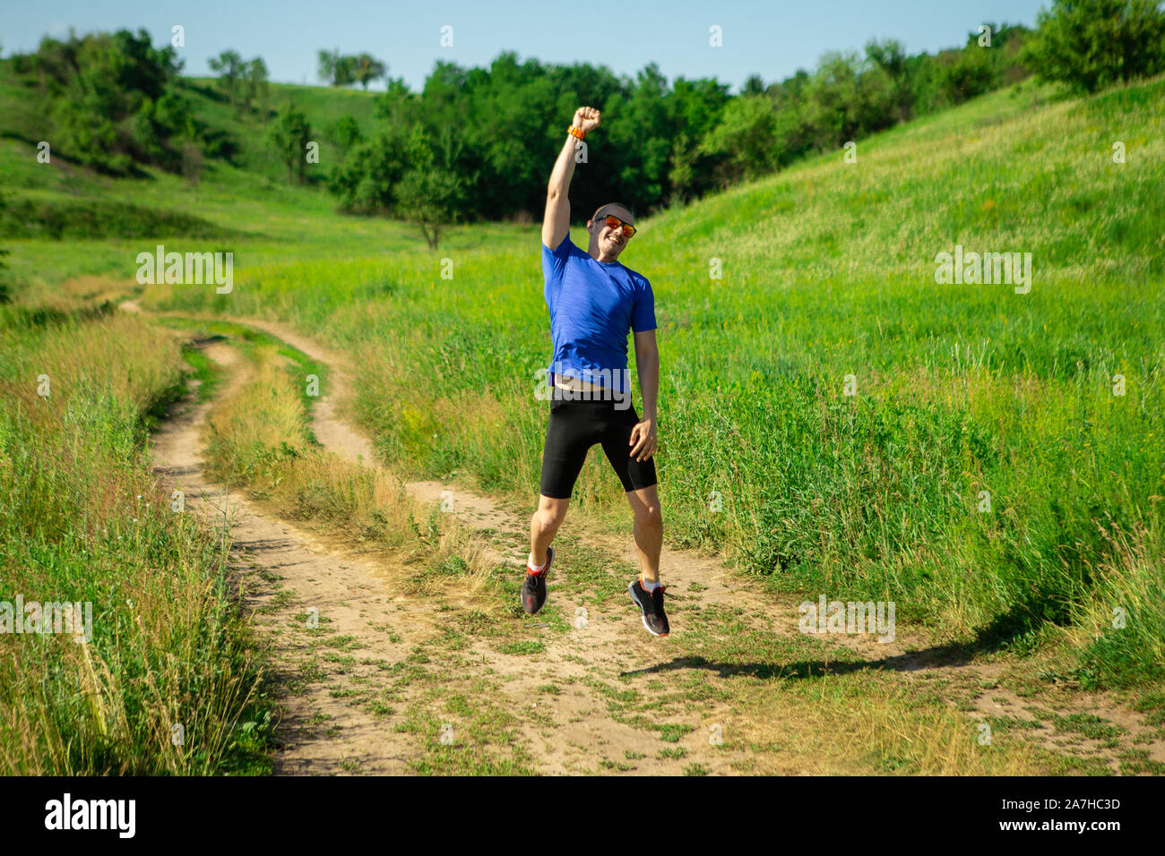 Homme runner de saut et de montrer comme il est vainqueur de la course Banque D'Images
