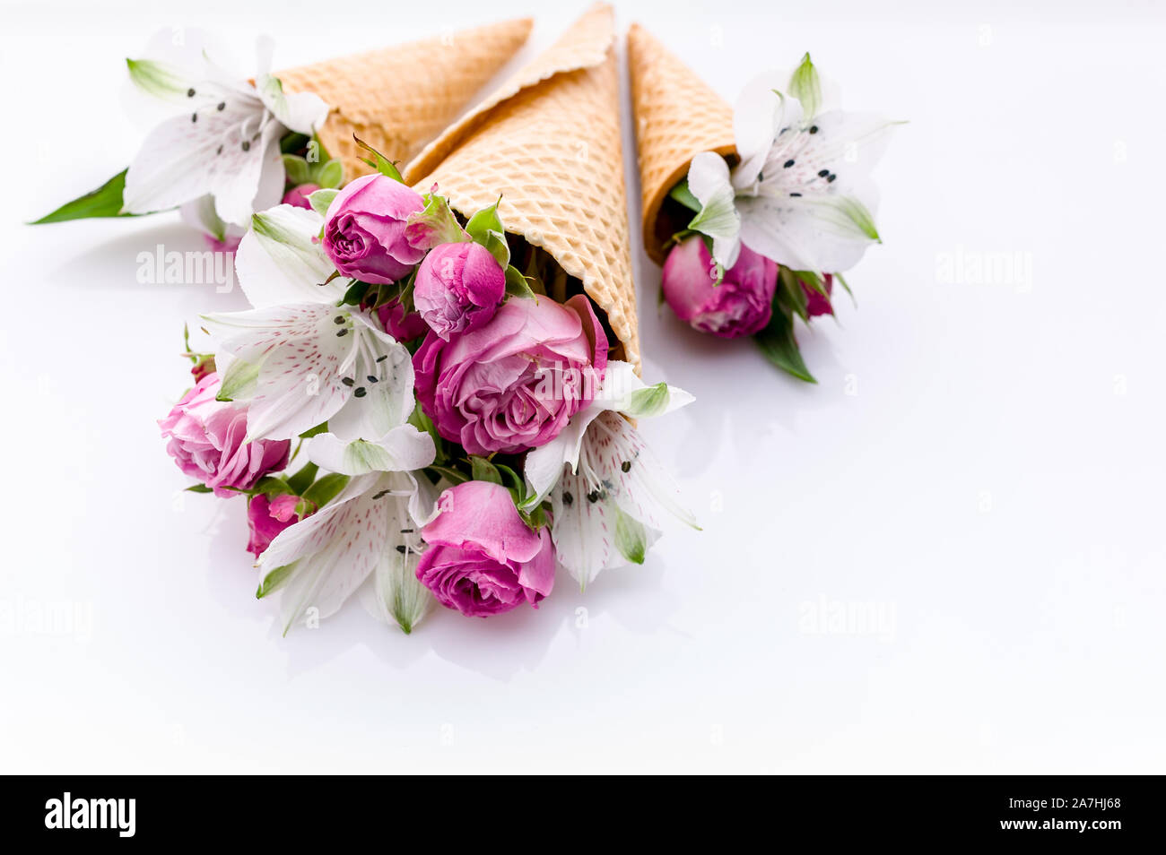 Décoration de mariage. Les petits bouquets de fleurs dans les cônes de gaufre sur un fond blanc. Rose et alstrameria. Thème pour les cartes de vœux ou mariage invitat Banque D'Images