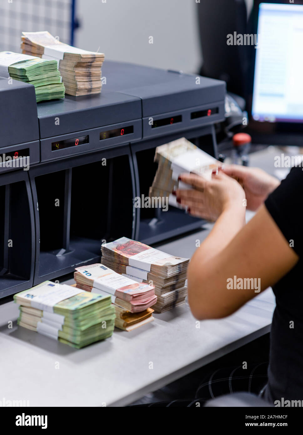 Femme de bureau piles de réarranger l'argent divisé avec des sangles de  monnaie à côté de l'appareil de comptage Photo Stock - Alamy