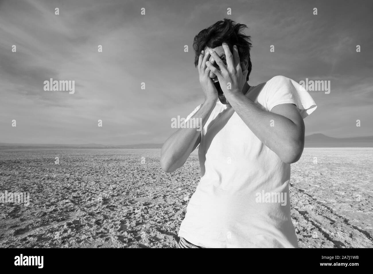 San Pedro de Atacama, Antofagasta, Chili - 01 novembre, 2012 : Le jeune homme crier protège son visage de la vent puissant dans le désert d'Atacama Banque D'Images