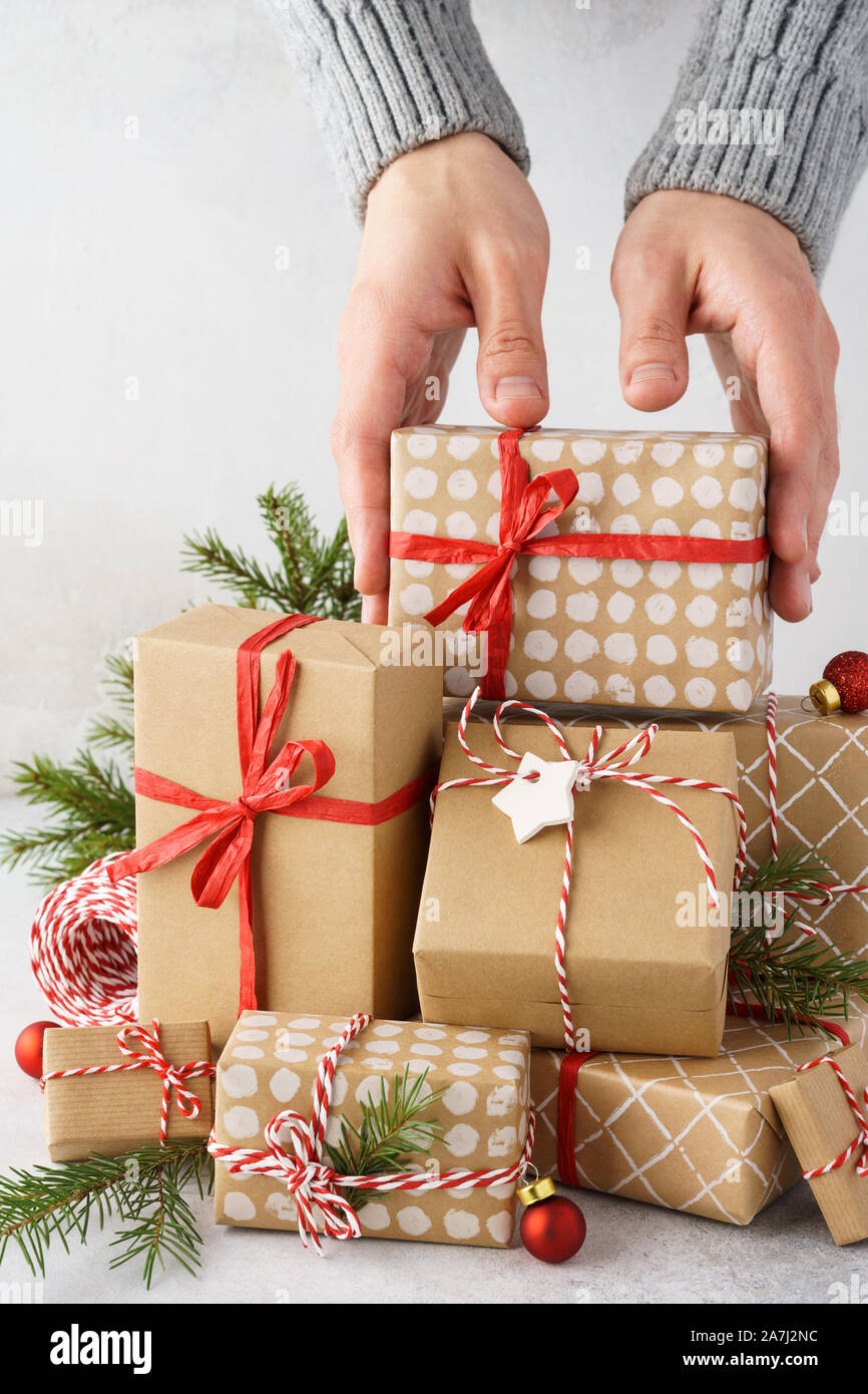 La prise de main d'hommes d'un cadeau d'une grande pile de cadeaux. Préparation de Noël. Banque D'Images