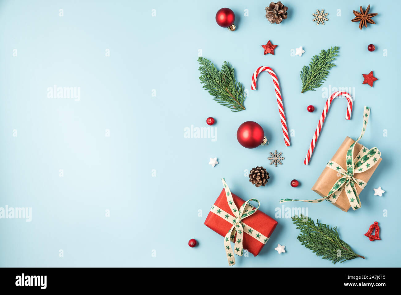 Noël arrière-plan. Des branches de sapins, des boîtes-cadeaux, décorations rouges, des bonbons, des pommes de pin sur fond bleu. L'hiver, Noël, nouvel an concept. Télévision Banque D'Images