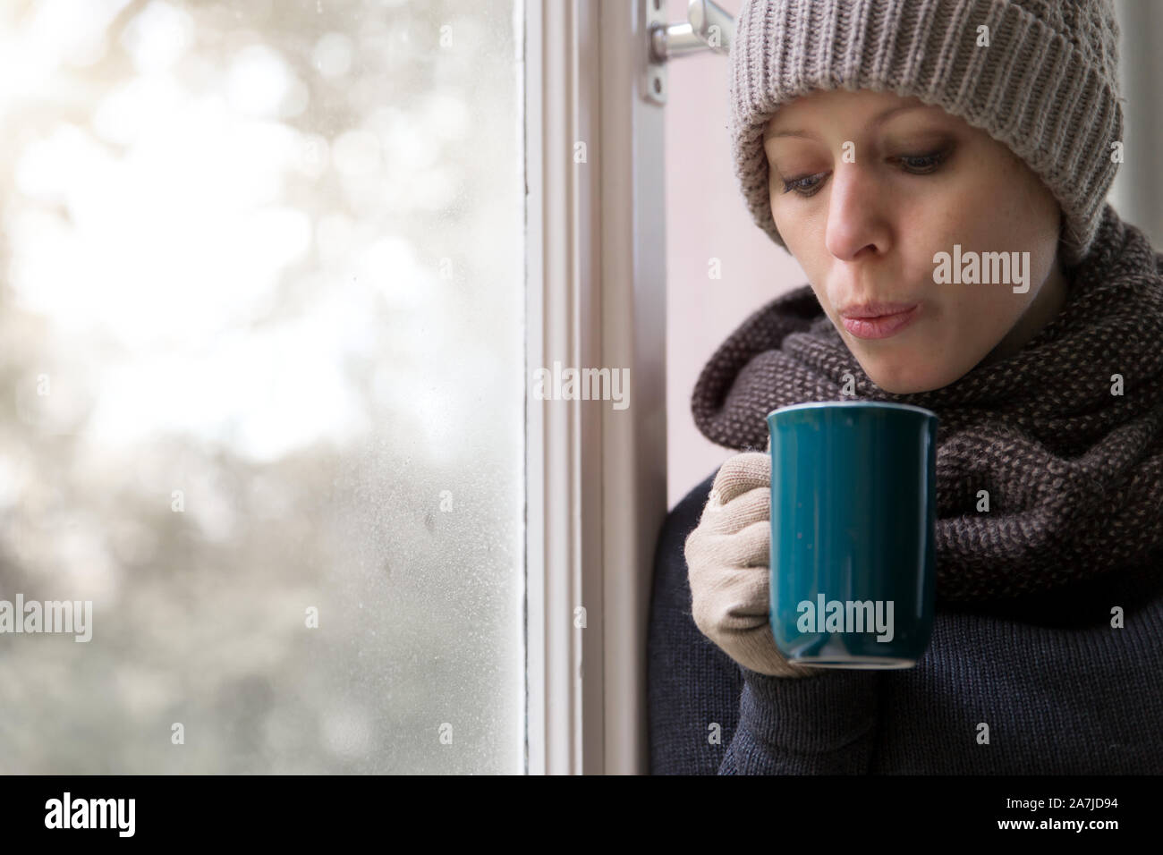 Femme est de boire quelque chose à l'intérieur dans la saison d'hiver chaud Banque D'Images