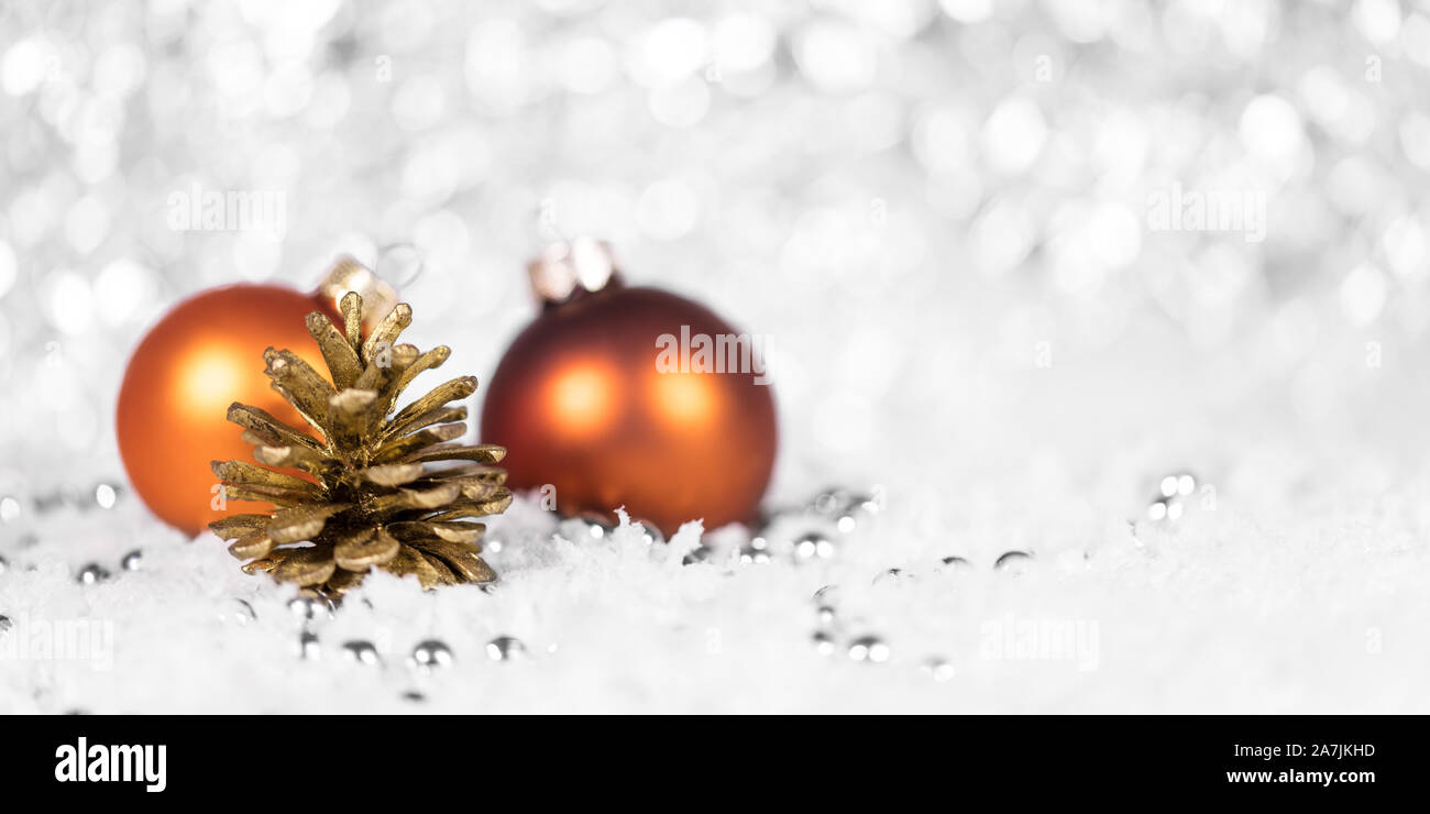 Boules Orange et le cône avec des perles dans la neige, l'arrière-plan pour la fête du temps de Noël Banque D'Images