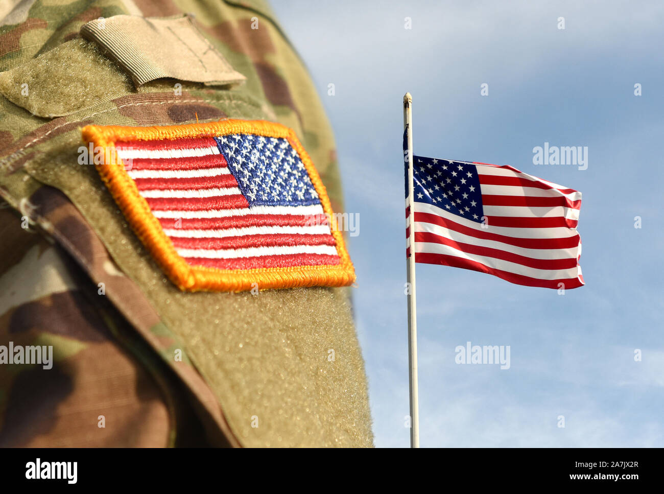 Journée des anciens combattants. Soldat américain. US Army. Des militaires aux Etats-Unis. Uniforme de l'armée US flag patch et Pavillon d'USA en zigzag dans le ciel. Banque D'Images